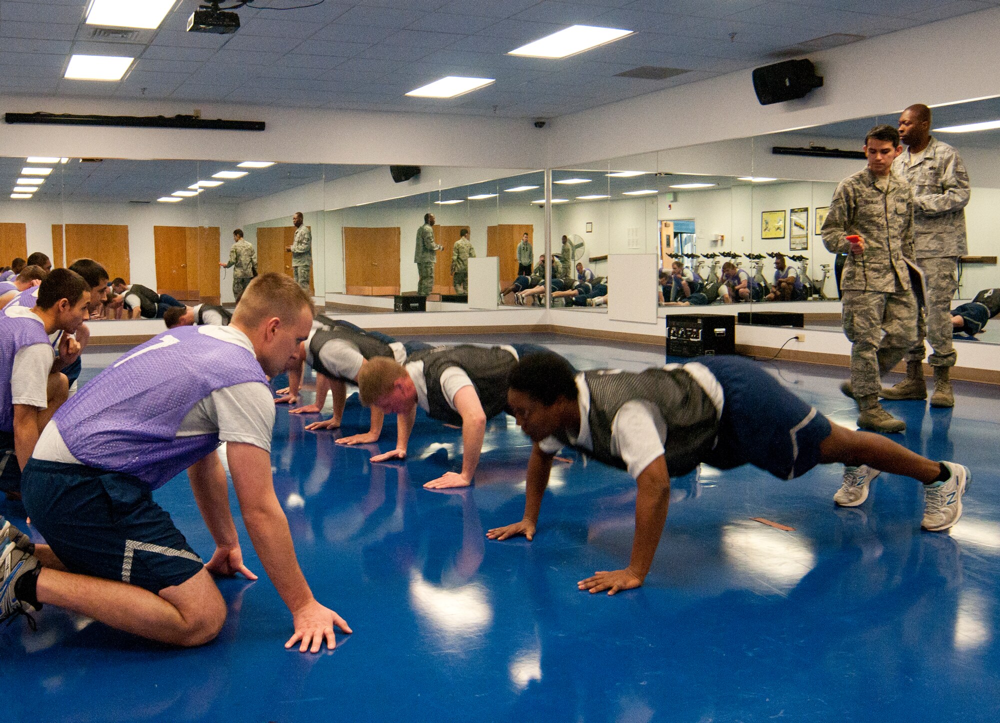Airmen take the pushup portion of the Air Force fitness assessment, which entails doing as many pushups as possible within one minute, March 4, 2014, in the Indepence Hall Fitness Center on F.E. Warren Air Force Base, Wyo. Test takers count the number of pushups a wingman performs correctly, and then the two switch and the other Airman counts while the first counter performs pushups. The 90th Force Support Squadron Fitness Improvement Program intends to help Airmen who want to improve their fitness assessment scores, and increasing the number of pushups they can perform is one way to improve. (U.S. Air Force photo by Airman 1st Class Jason Wiese)