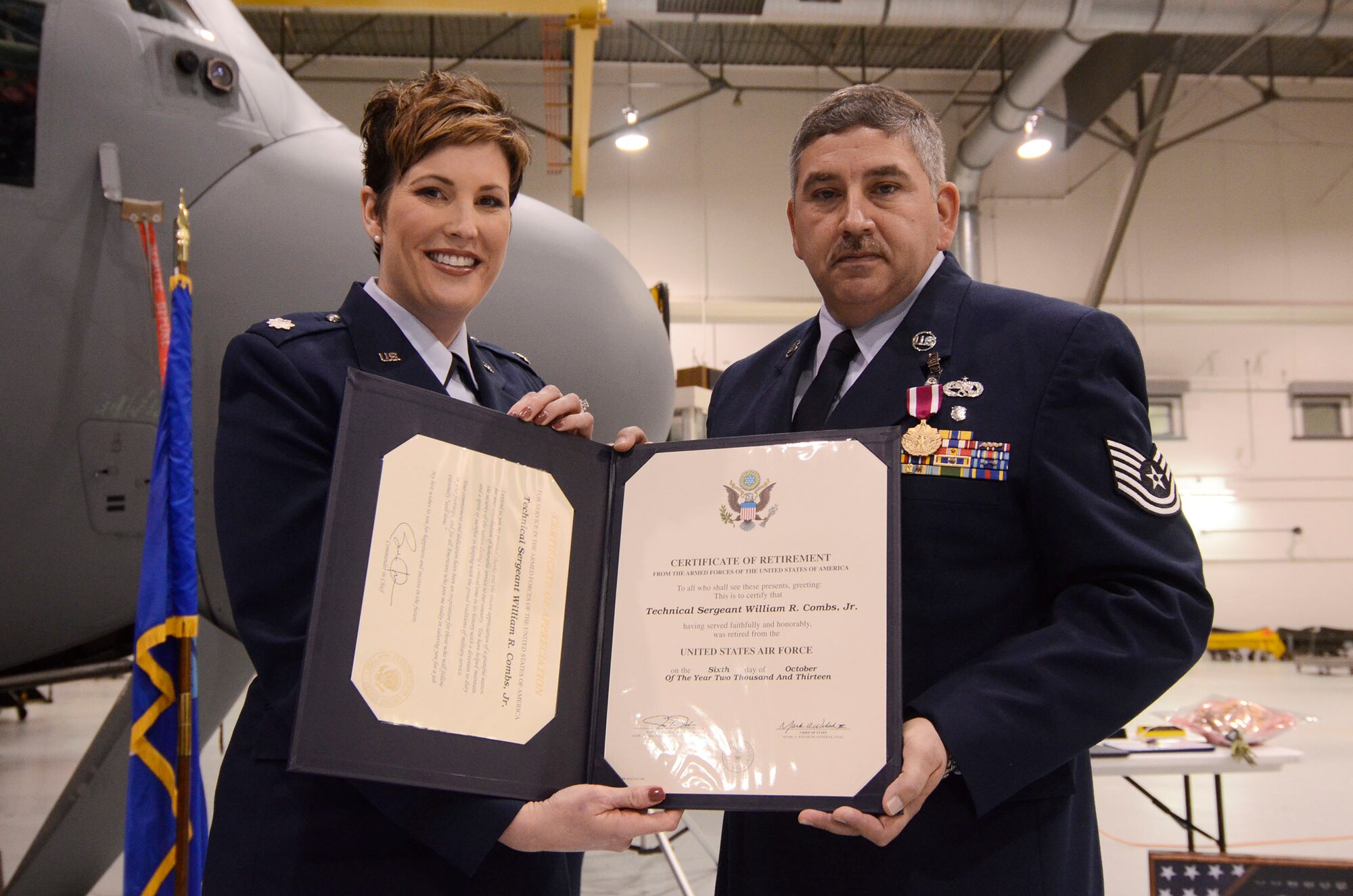 Lt. Col. Kerri Ebrecht, 94th Maintenance Squadron commander presents Tech. Sgt. William Combs, Jr. with a certificate of service during his retirement ceremony
Feb. 1. Combs was honored for 30 years of military service. (U.S. Air Force photo/Don Peek)