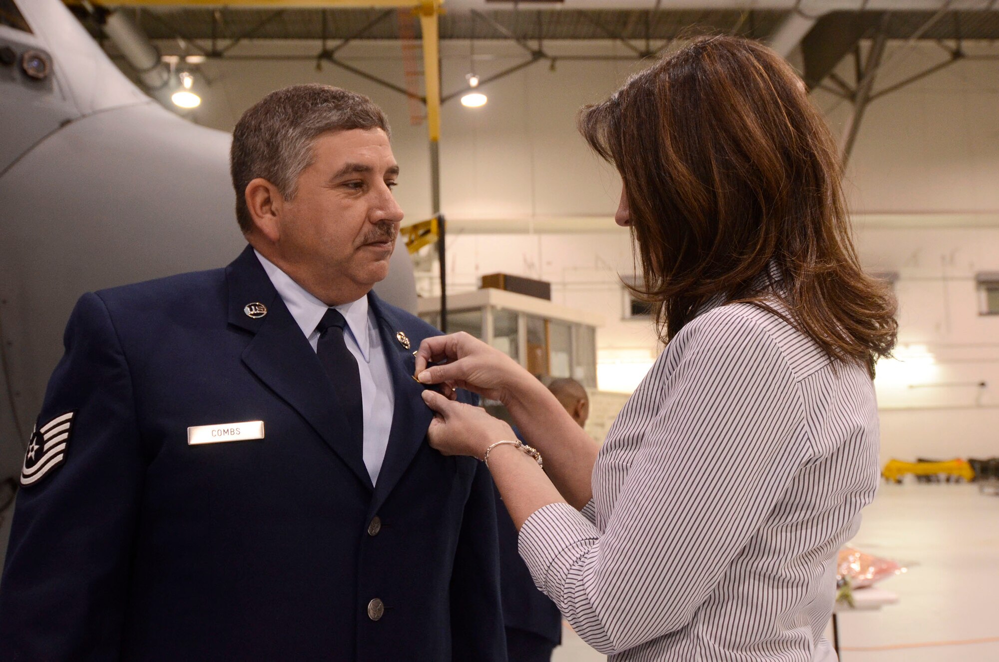Tech. Sgt. William Combs, Jr.'s wife Brigit assists him with the pinning of the Meritorous Service Medal during his retirement ceremony Feb. 1. Combs was honored for 30 years of military service. (U.S. Air Force photo/Don Peek)