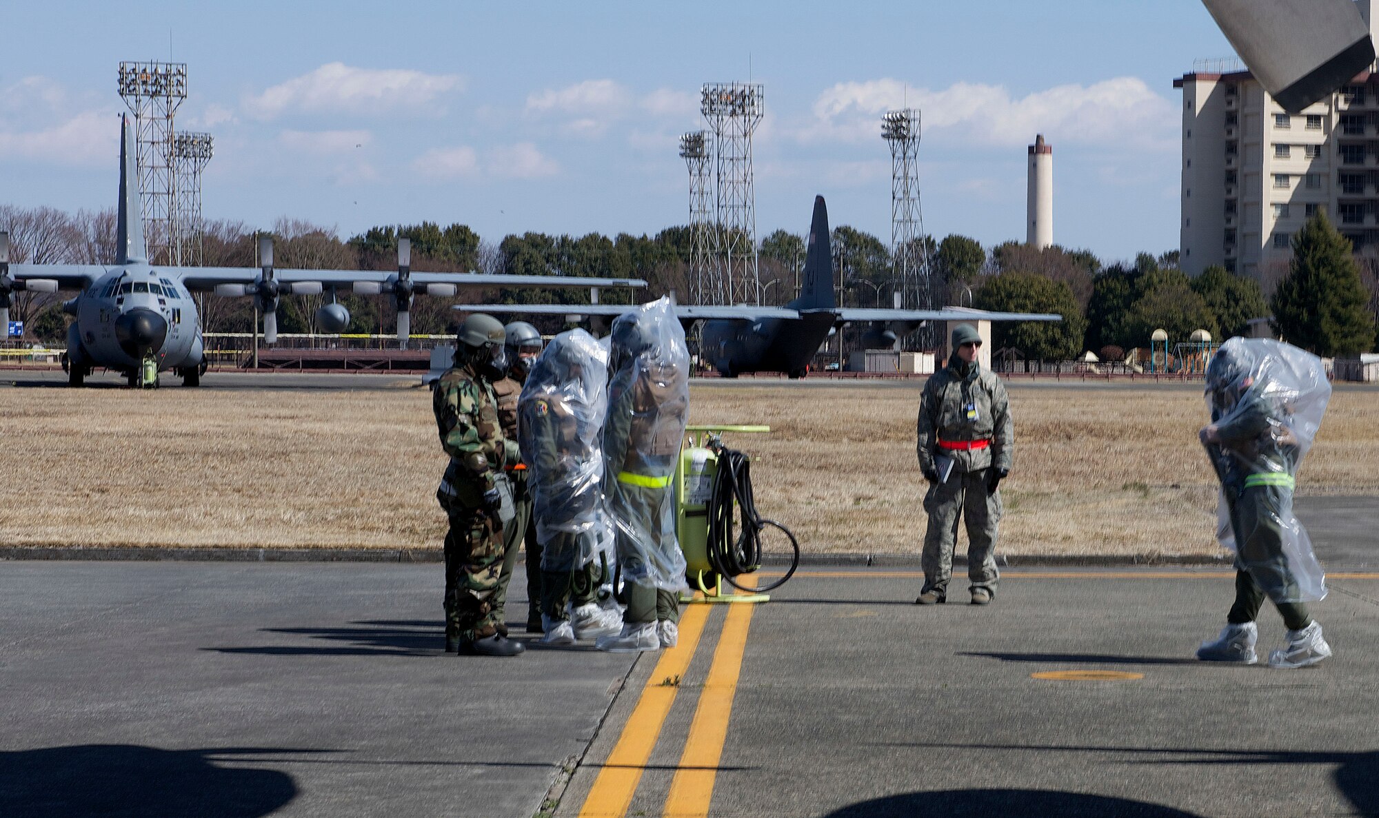 Aircrew disembark a contaminated C-130 Hercules wearing their mission-oriented protective posture gear during Samurai Readiness Inspection at Yokota Air Base, Japan, March 6, 2014. The Aircrew performed a chemical warfare scenario as part of the inspection to ensuring they were prepared to support the Pacific theater under any condition. (U.S. Air Force photo by Airman 1st Class David Danford / released)