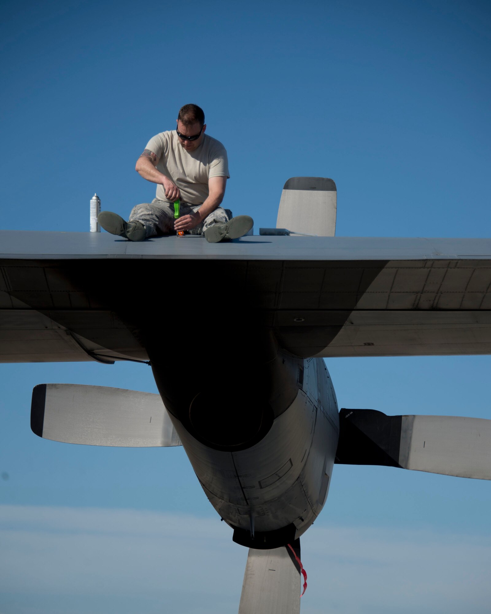 Master Sgt. Tom Heckman, 133rd Aircraft Maintenance Squadron, sits on the wing of a C-130 Hercules in Yuma, Ariz., Feb. 26, 2014. Heckman is conducting a pre-flight inspection. 
(U.S. Air National Guard photo by Tech. Sgt. Amy M. Lovgren/Released) 