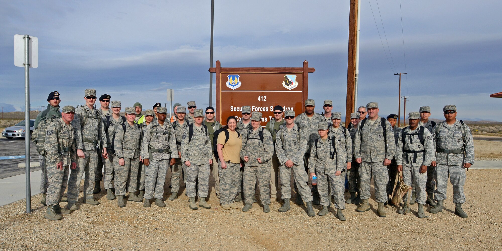 The ruck march participants pose for a group photo at the Combat Arms Training and Maintenance building where the march began March 4. (U.S. Air Force photo by Jet Fabara)