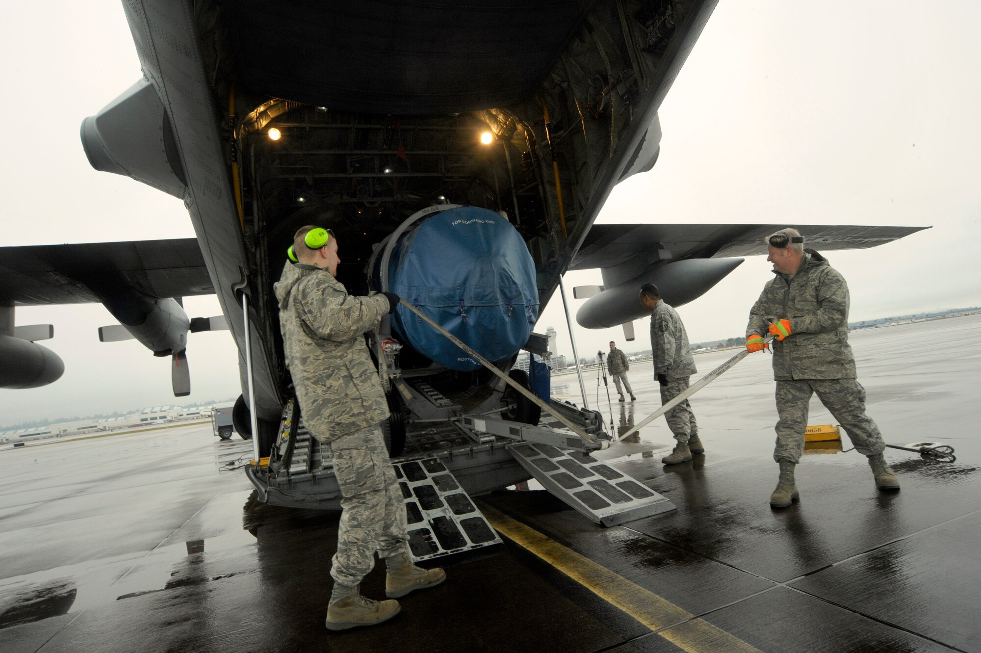 Oregon Air National Guard airmen Senior Airman Ryan Rosso (left) and Staff Sgt. Dan Beard (right) move equipment into a C-130 Hercules, at the Portland Air National Guard Base, Ore., Feb. 27, 2014. Rosso and Beard, 142nd Fighter Wing Logistics Readiness Squadron members, are packing equipment that will be used in the Red Flag exercise at Nellis Air Force Base, Nev. (U.S. Air National Guard photo by Tech. Sgt. John Hughel/Released)