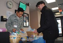 Capt. Chris Ordonez, 319th Medical Group infection preventionist, shows Ron Pack some of the free items offered to guests March 3, 2014, at the pharmacy on Grand Forks Air Force Base, N.D. The 319th Medical Group offered free items such as hand sanitizers and pill crushers to help raise awareness for National Patient Safety Week. (U.S. Air Force photo/Staff Sgt. Luis Loza Gutierrez) 
