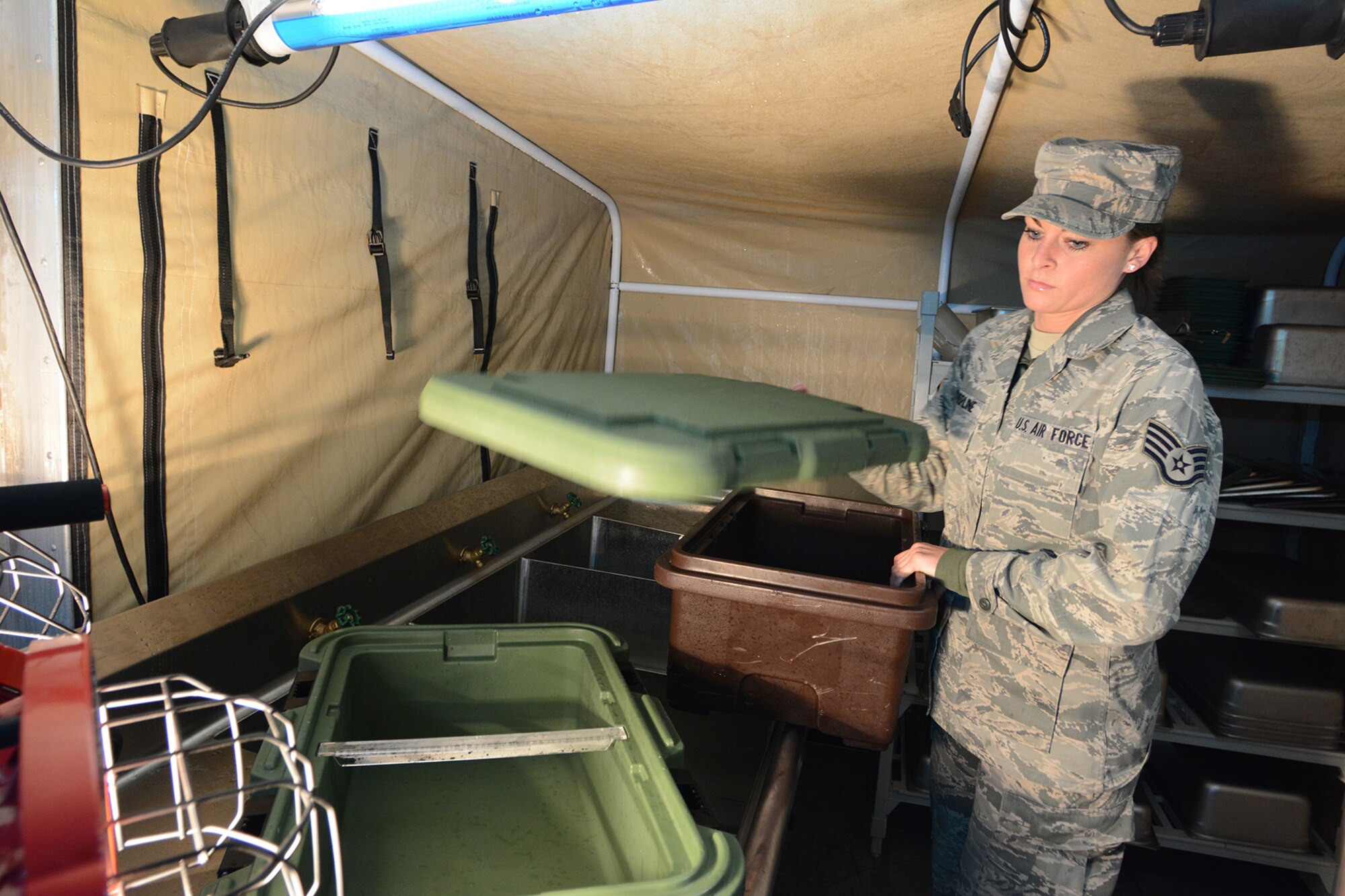 Staff Sgt. Angela Krepline, 115th Force Support Squadron services, prepares for lunch in the Single Pallet Expeditionary Kitchen during Cajun Care 2014 in Abbeville, La., March 4, 2014. There were six Airmen from the 115th FSS who were in charge of providing two meals per day to approximately 100 people during the 10-day mission. (Air National Guard photo by Senior Airman Andrea F. Liechti)