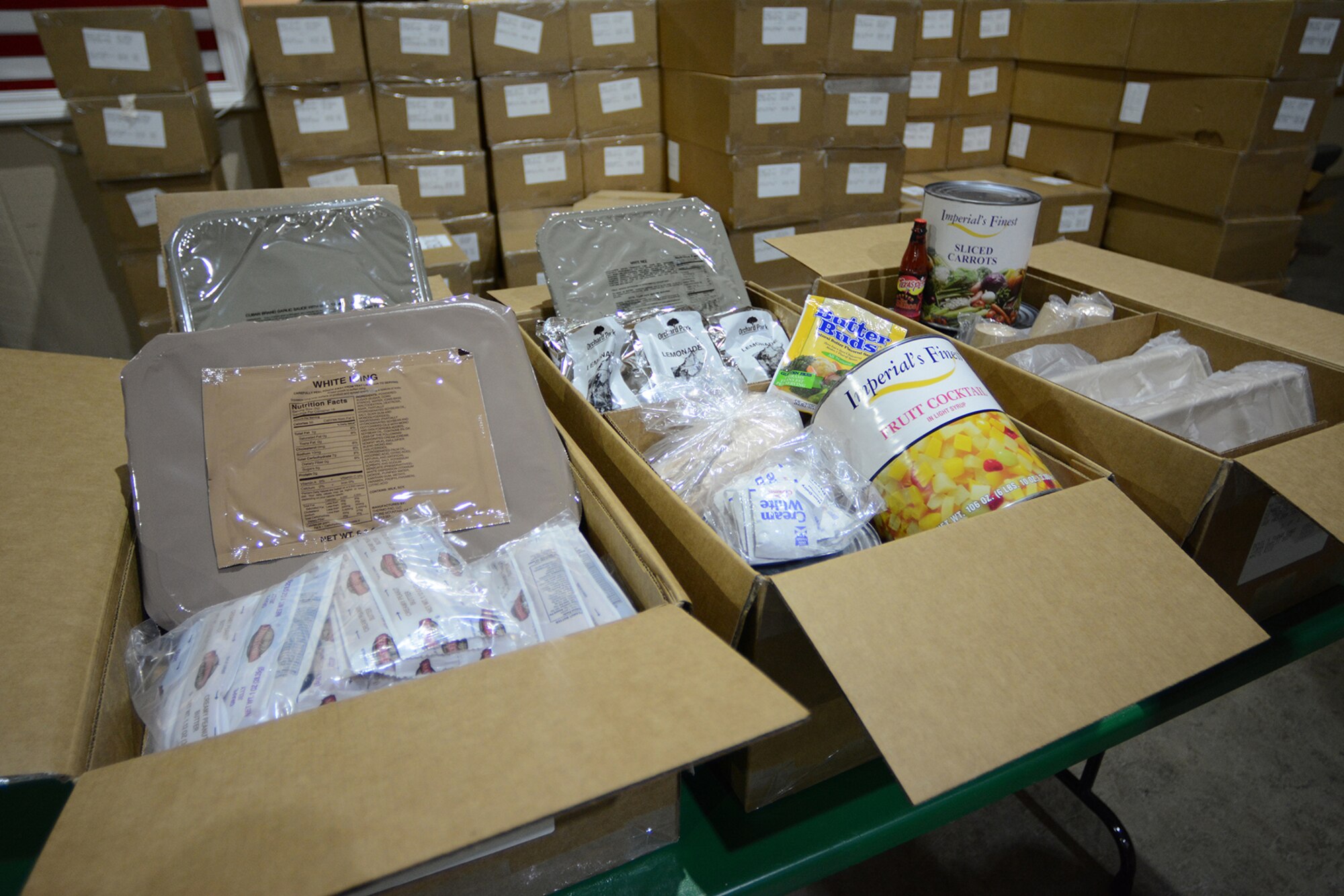 Food from a Unitized Group Ration is displayed in the Armory during Cajun Care 2014 in Abbeville, La., March 4, 2014. Three UGR boxes contain enough food to feed 50 people. The 115th Force Support Squadron services Airmen used the Single Pallet Expeditionary Kitchen they deployed with to cook the food each day. (Air National Guard photo by Senior Airman Andrea F. Liechti)