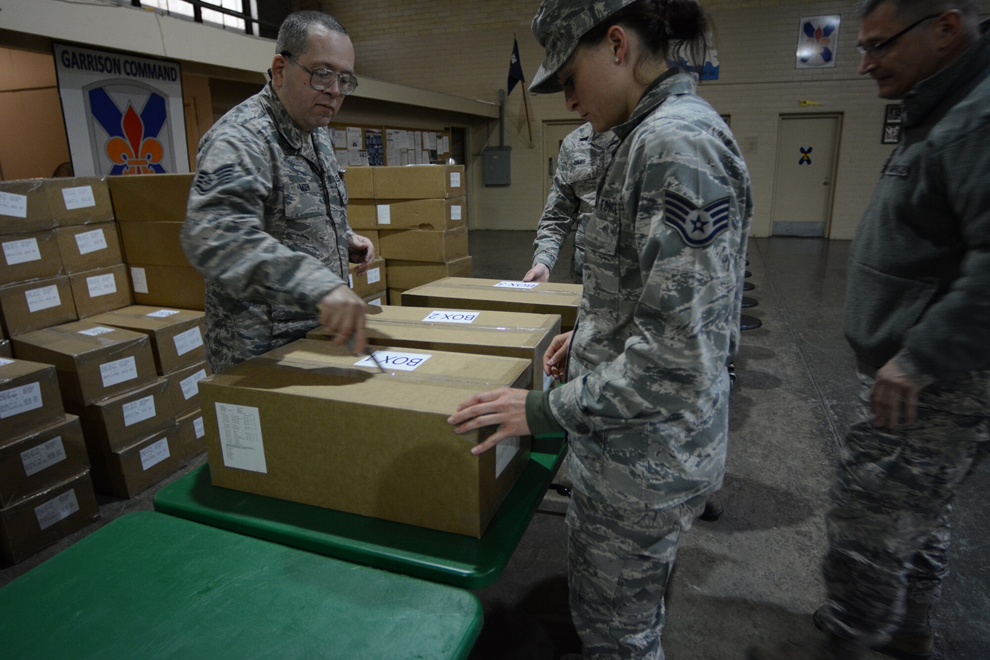 The 115th Force Support Squadron services Airmen open boxes of food in preparation for lunch during Cajun Care 2014 in Abbeville, La., March 4, 2014. The team of six brought down 11 pallets of Unitized Group Rations. Three boxes of UGRs contained enough food to feed 50 people. The Airmen fed approximately 100 people per day during the 10-day mission using the Single Pallet Expeditionary Kitchen they brought down with them from Madison, Wis. (Air National Guard photo by Senior Airman Andrea F. Liechti)