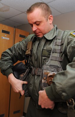 Tech. Sgt. Tim McKinley, 54th Helicopter Squadron flight engineer, positions a vest that is used to carry items that are important on a mission at Minot Air Force Base, N.D., Feb. 21, 2014. McKinley and other flight engineers provide support to a multitude of missions monthly. (U.S. Air Force photo/Senior Airman Andrew Crawford)