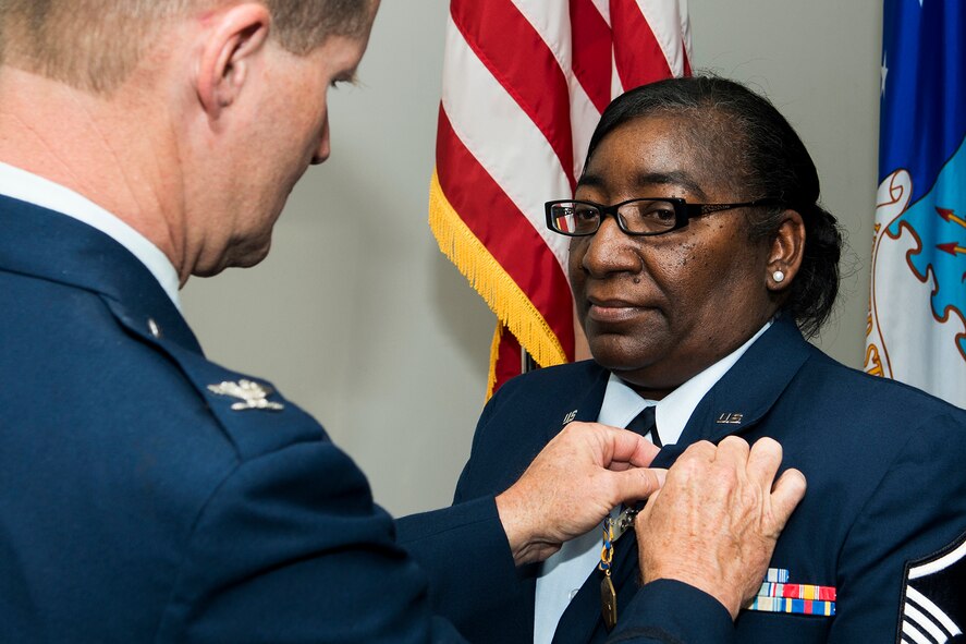 U.S. Air Force Col. Dean Robinson, 307th Medical Squadron (MDS) commander, presents the Air Force Commendation Medal to Master Sgt. Debra Phenix during her retirement ceremony, Mar. 2, 2014, Barksdale Air Force Base, La. Phenix is awarded the medal for distinguished and meritorious service while assigned to the 307th MDS. (U.S. Air Force photo by Master Sgt. Greg Steele/Released)