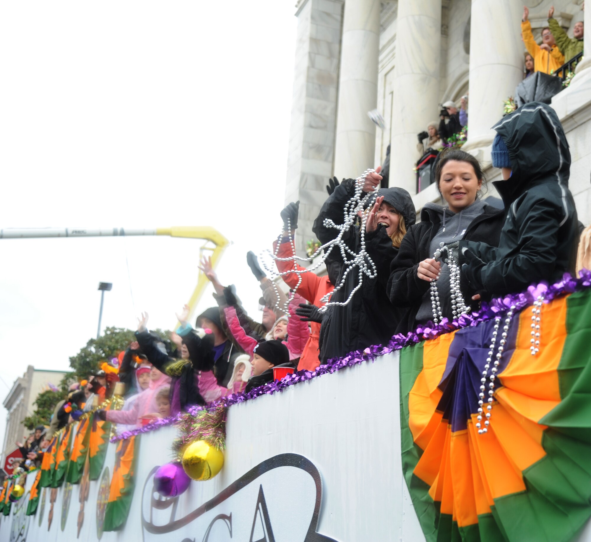 The wife of Col. Frank Amodeo, 403rd Wing commander, catches beads during the Gulf Coast Carnival Association Mardi Gras parade in Biloxi, Miss., March 4, 2014. The Keesler Honor Guard and Col. René Romero, 81st Training Wing vice commander, also participated in the festivities. (U.S. Air Force photo by Kemberly Groue)