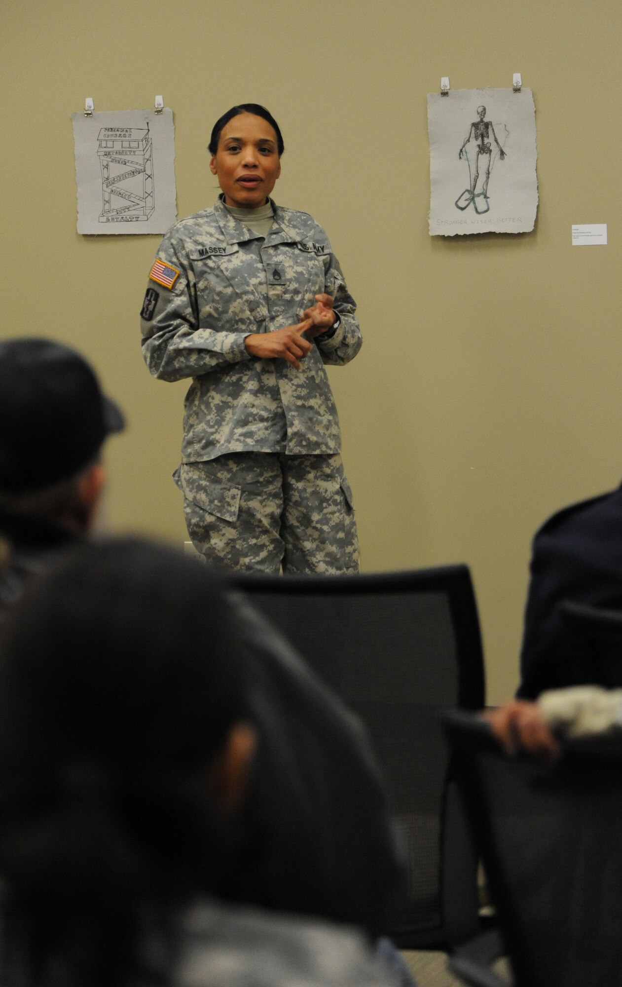 A Warrior Transition Unit Soldier shares a story about her deployment which was inspiration for her painting at the Combat Paper New Jersey exposition Feb. 28, 2014, at Joint Base McGuire-Dix-Lakehurst, N.J. Participants create artwork during the week-long workshop where they shred a uniform and turn it into paper to communicate a military story. (U.S. Air Force photo by Airman 1st Class Sean M. Crowe/Released)