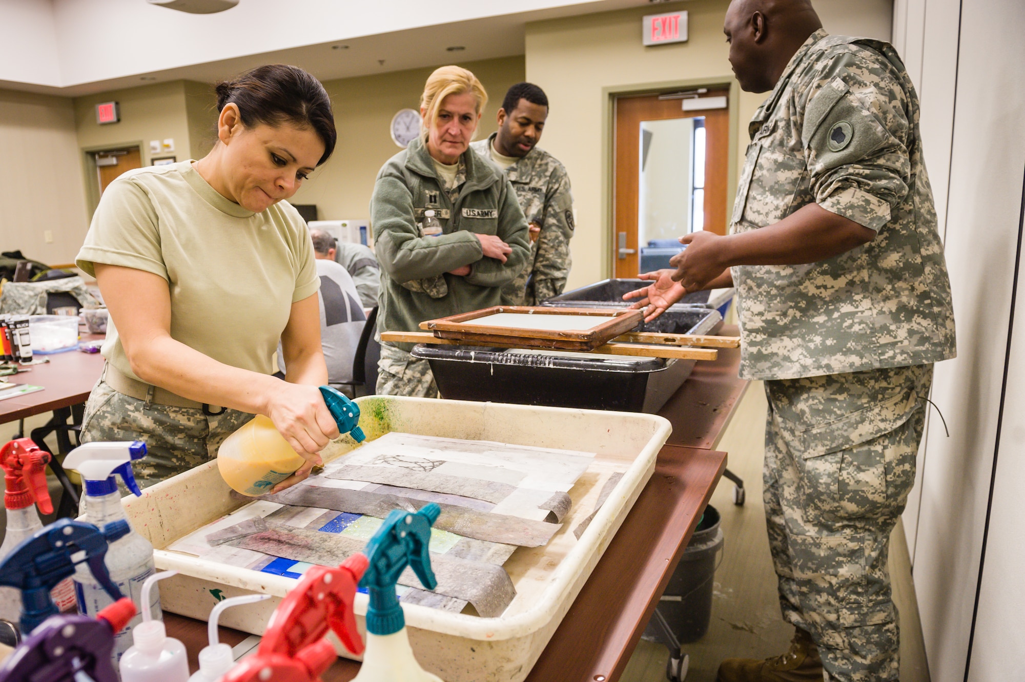 Army Staff Sgt. Kennia Zavala, Warrior Transition Unit medic, applies pulp spray to an art project at the Combat Paper New Jersey workshop Feb. 26, 2014, at Joint Base McGuire-Dix-Lakehurst, N.J. Old uniforms are shredded to create paper that they will use in drawings and paintings. CPNJ is run by veterans, for veterans. It provides a safe and comfortable setting where veterans can use art to communicate their military experience. Zavala hails from Duluth, Ga. (U.S. Air Force photo by Russ Meseroll/Released)