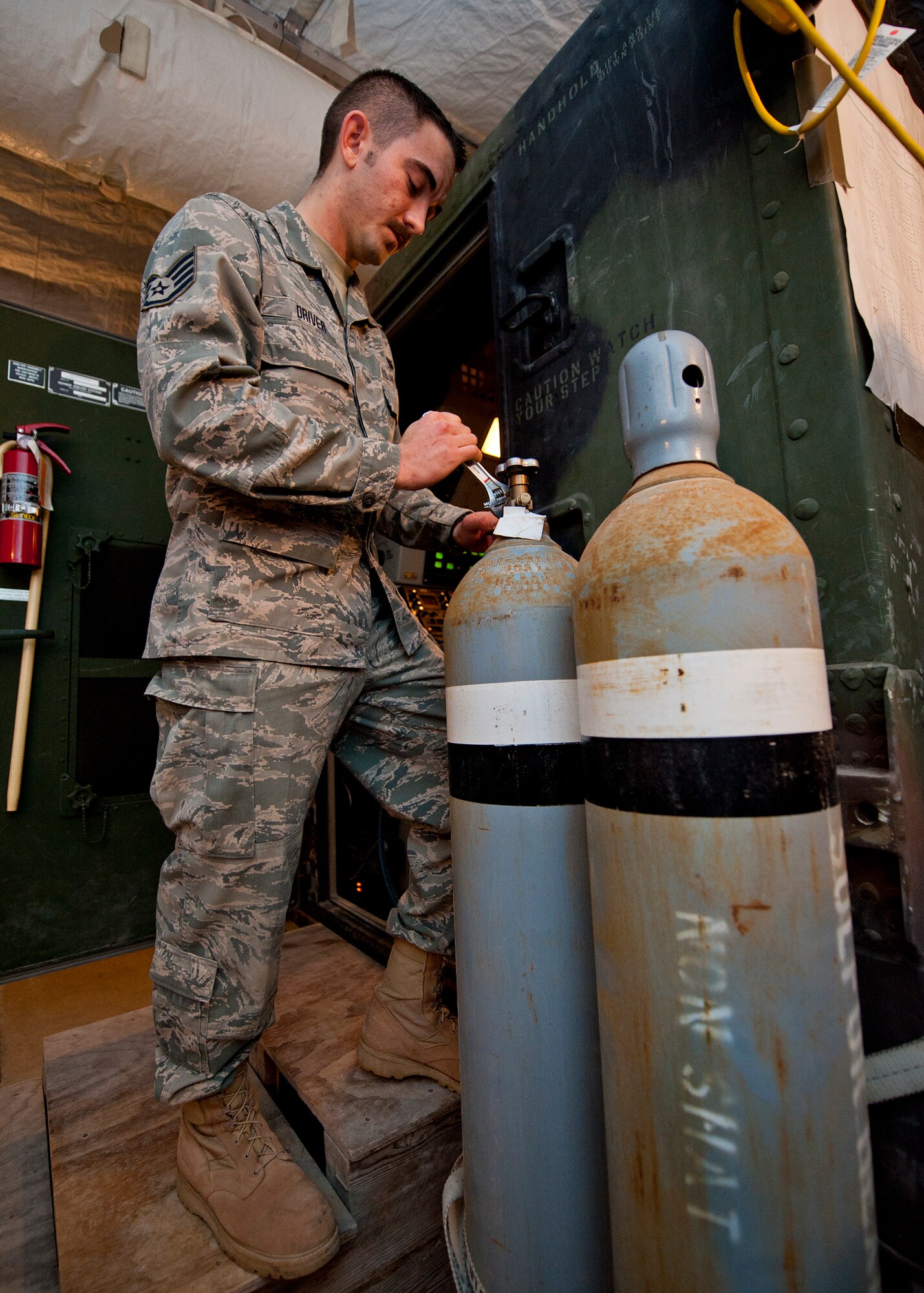 Staff Sgt. Aaron Driver, a ground radar systems technician assigned to the 727th Expeditionary Air Control Squadron, charges the SF-6 tank used for the radar system high voltage components at an undisclosed location in Southwest Asia, March 5, 2014. Driver is a native of Savannah, Ga., and is deployed here from Hunter Army Airfield. (U.S. Air Force photo by Staff Sgt. Michael Means/Released)