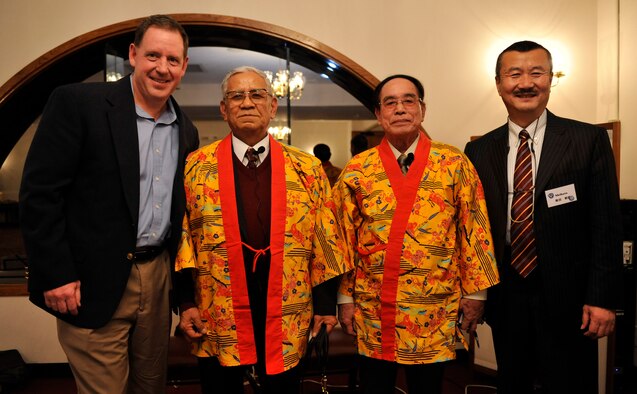 U.S. Air Force Brig. Gen. James Hecker, 18th Wing commander and Japanese Ground Self-Defense Force retired Lt. Gen. Mikio Shibata, leader of Japan-America Air Force Goodwill Association, take a picture with Sanshin (Okinawa traditional guitar) great masters during the JAAGA tour at the Kadena Officer's Club on Kadena Air Base, Japan, March 4, 2014. JAAGA is an organization mainly composed of Japan Air Self Defense Force veterans. Its objective is to contribute to the promotion of friendship and mutual understanding between the JASDF and the U.S. Air Force. (U.S. Air Force photo by Naoto Anazawa)