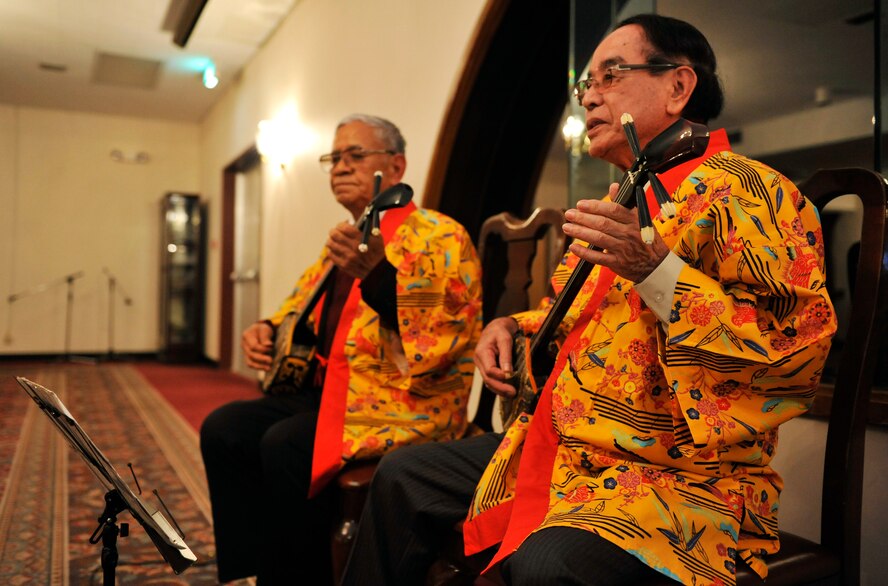 Eishin Matsuda (left) and Teruo Yamauchi (right), Sanshin (Okinawa traditional guitar) great masters, perform Okinawan folksongs during the Japan-America Air Force Goodwill Association tour at the Kadena Officer's Club on Kadena Air Base, Japan, March 4, 2014. JAAGA is a community organization aimed at promoting friendship and mutual understanding between Japan Air Self Defense Force and the U.S. Air Force. (U.S. Air Force photo by Naoto Anazawa)
