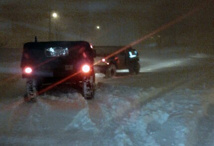 Two Humvees depart the Wisconsin Army National Guard's Oak Creek armory Feb. 1, 2011, in response to a call for assistance during severe winter storm. Wisconsin Guard members are preparing for another storm now.