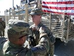 U.S. Army Capt. Robert Bejarano, commander of the 216th Mobility Augmentation Company, 365 th Engineer Battalion, awards Cpl. Christopher Garland the Army Commendation Medal with "V" Device, for valor, and a Combat Medic Badge, at Forward Operating Base Ghazni.
