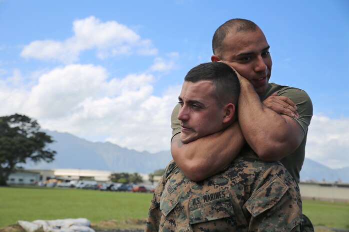 Sgt. Rey Campos, a platoon sergeant with the distribution management office and a Marine Corps Martial Arts Program instructor, performs a choke hold on Lance Cpl. Santiago Cruz, a distribution management clerk, March 5, 2014. (U.S. Marine Corps photo by Lance Cpl. Suzanna Knotts) 