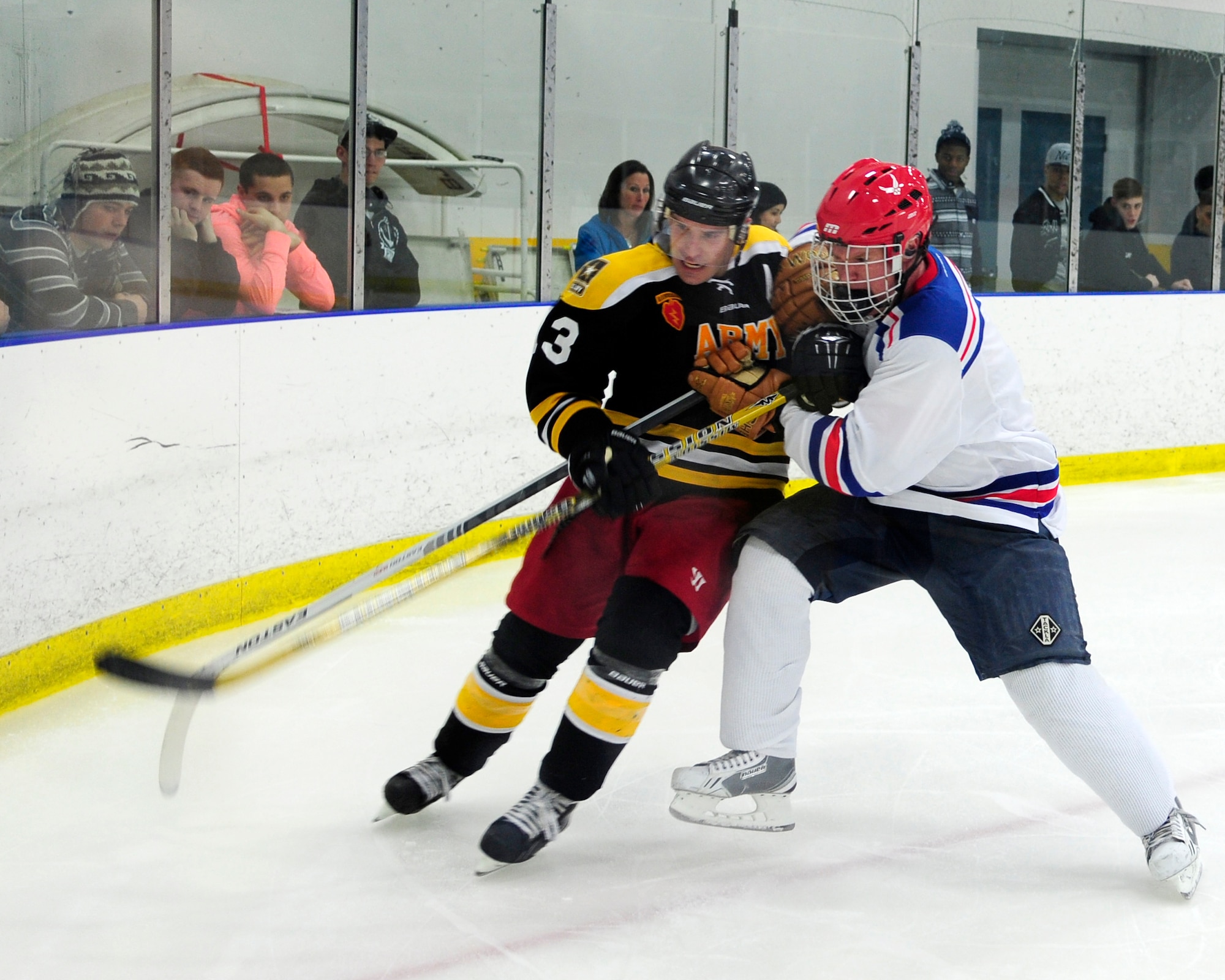Erik Fitzstephens, Eielson defenseman, battles into the corner against Caleb Goble, Interior Alaska-Based Army Hockey Team defenseman, during the Commanders’ Cup hockey game at the University of Alaska Fairbanks Patty Center, Feb. 28, 2014, Fairbanks, Alaska. The game drew a capacity crowd of more than 2,000 people. (U.S. Air Force photo/Tech. Sgt. Tim Jenkins)