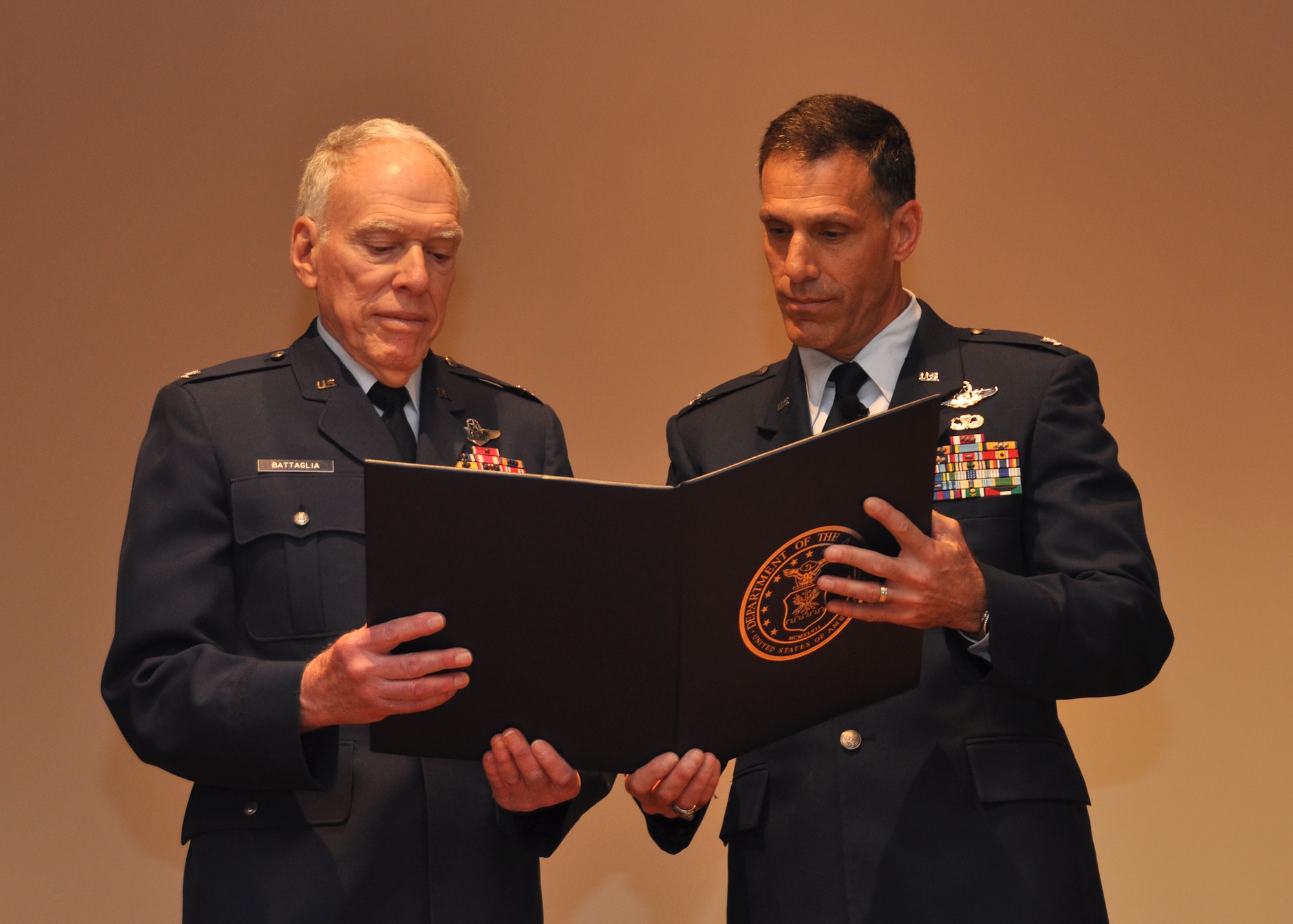 Col. Joseph H. Battaglia, II, (right) looks over his retirement certificate with his father, retired Col.Joseph Battaglia, who presided over his son's retirement ceremony, March 1, at Beale Air Force Base, Calif. The colonels each served 30 years in the Air Force. before retiring.The younger Battaglia's final assignment was as commander of the 940th Wing Operations Group at Beale. (U.S. Air Force photo/Tech.Sgt. Heather Skinkle)   