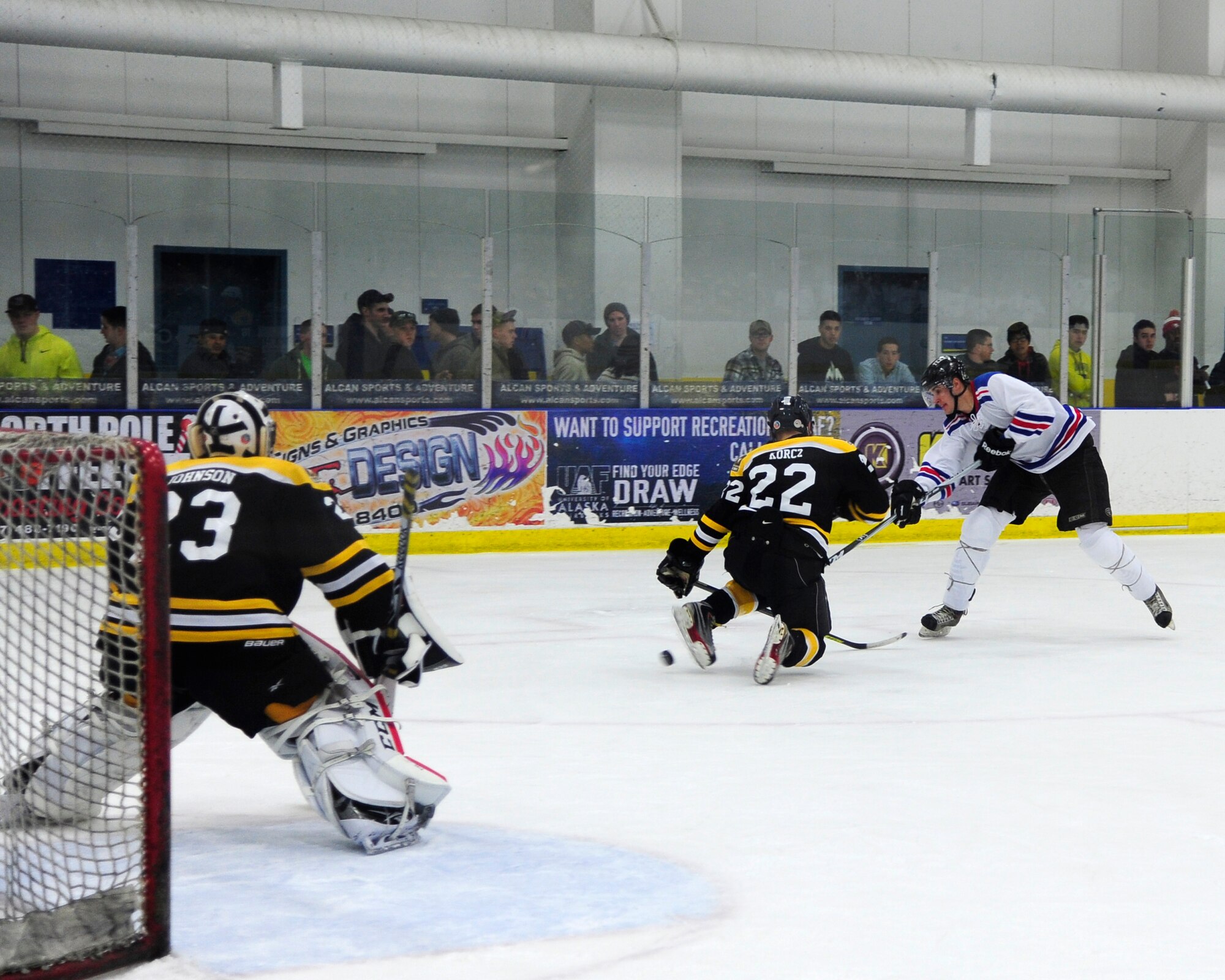 Skylar Chupp, Eielson right wing, puts a shot under Army defenseman Johnathan Korcz in the first period of the Commanders’ Cup hockey game at the University of Alaska Fairbanks Patty Center, Feb. 28, 2014, Fairbanks, Alaska. The Eielson Icemen earned an 8-5 win, keeping the Commanders’ Cup for the second year in-a-row and for the 10th time overall. (U.S. Air Force photo/Tech. Sgt. Tim Jenkins)