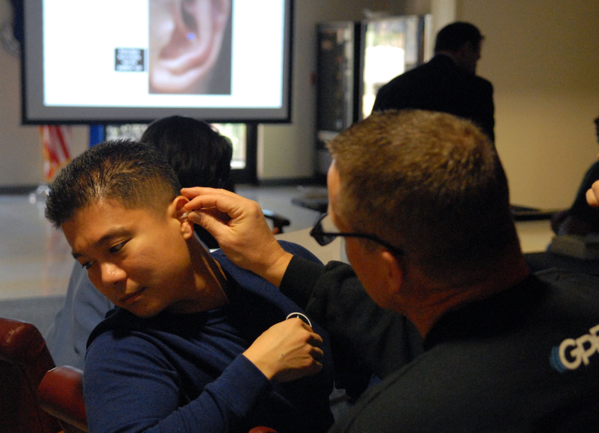 Capt. Yusharn Wang (left), Family Health Nurse Practitioner and Col. Daniel Weaver, acting Chief of Medical Services, both from the 78th Medical Group, practice Auricular Therapy Acupuncture points to learn the acupuncture points, March 1, 2014.  The human ear has many points that relieve headaches and muscle pains all over the body. (U.S. Air Force photo by Misuzu Allen)