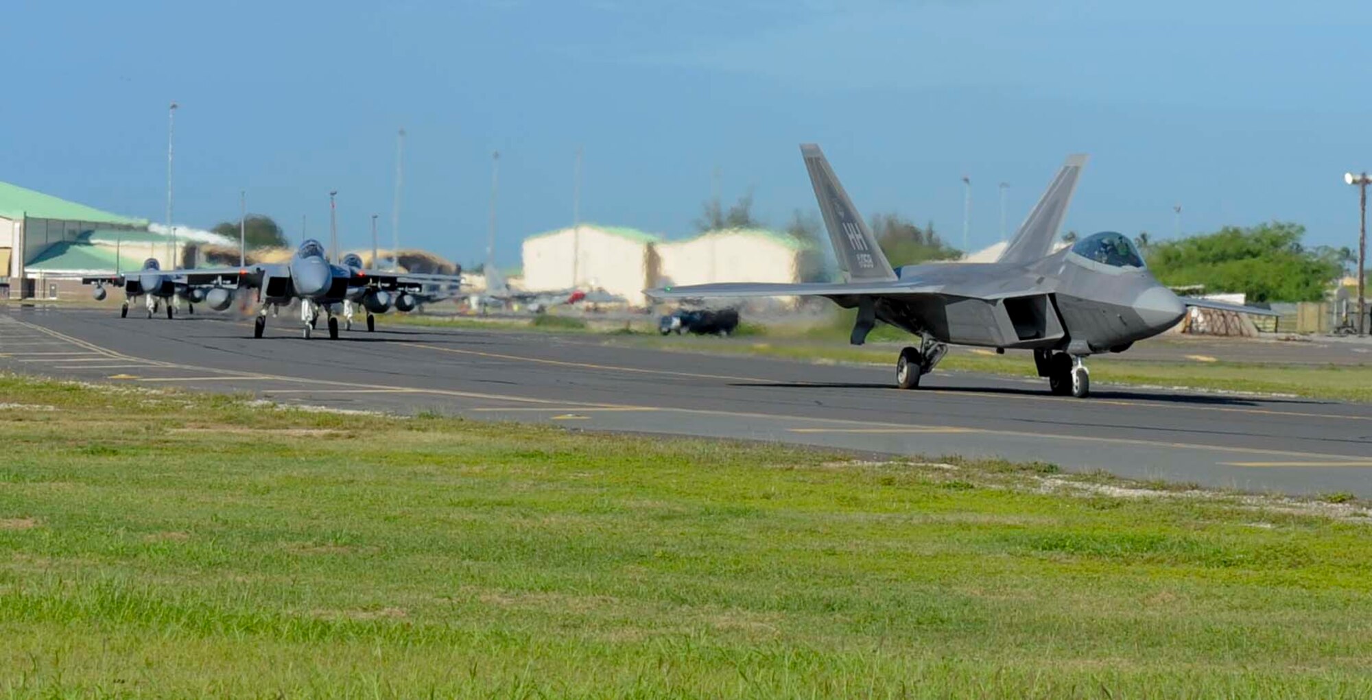 A Hawaii Air National Guard F-22 Raptor and several F-15 Eagles from the 104th Fighter Wing in Massachusetts taxi the runway at Joint Base Pearl Harbor-Hickam, Hawaii, in preparation to launch. The aircraft are participating in Sentry Aloha, an aerial combat exercise focused on offensive and defensive counter measures and fighter integration.  This Sentry Aloha is the largest ever.  The exercise has been ongoing for the past three decades. (U.S. Air Force photo/Tech. Sgt Terri Paden)