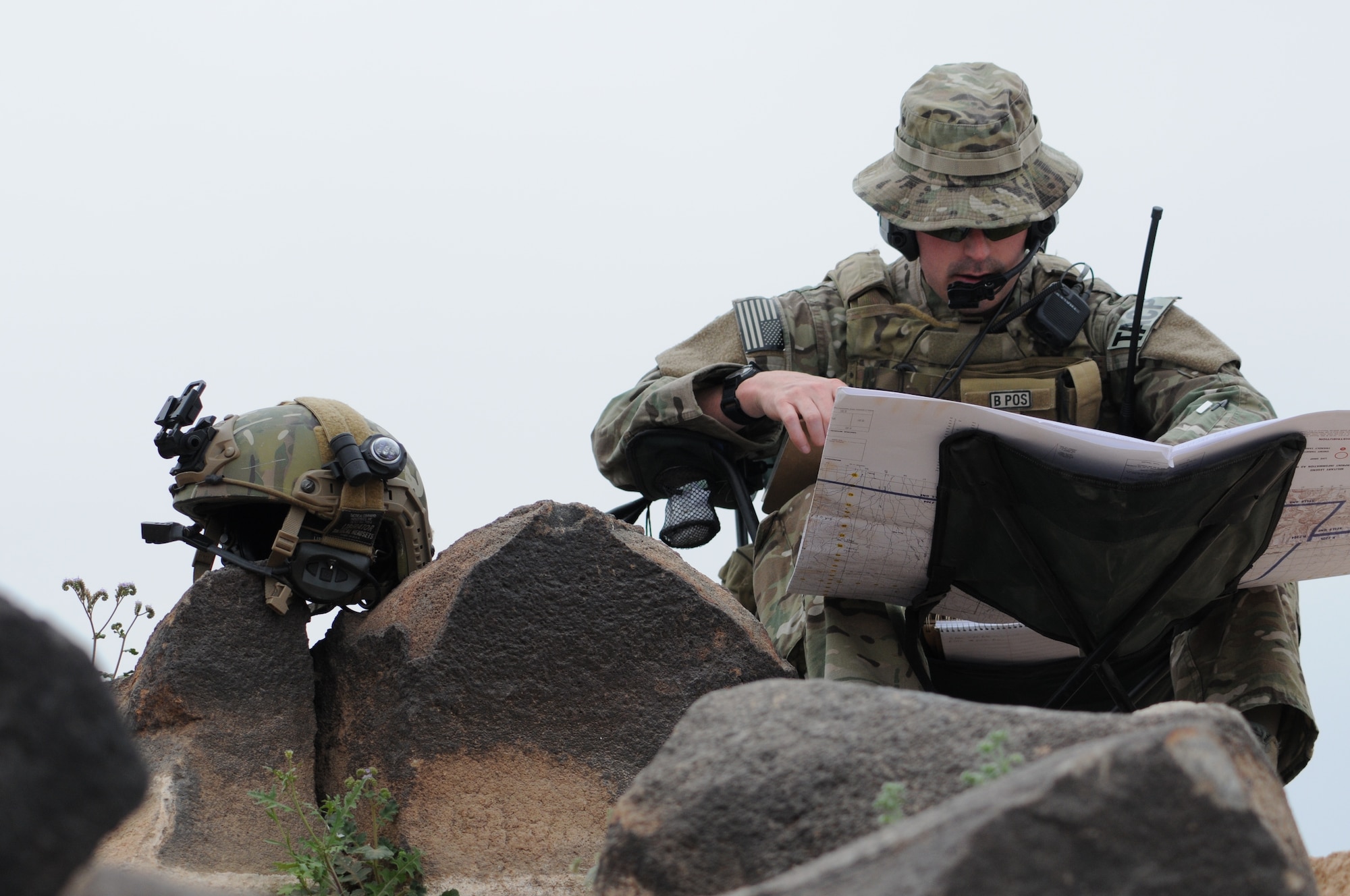 A picture of U.S. Air Force Tech. Sgt. Wayne White, a tactical air control party airman using a range map and radio.