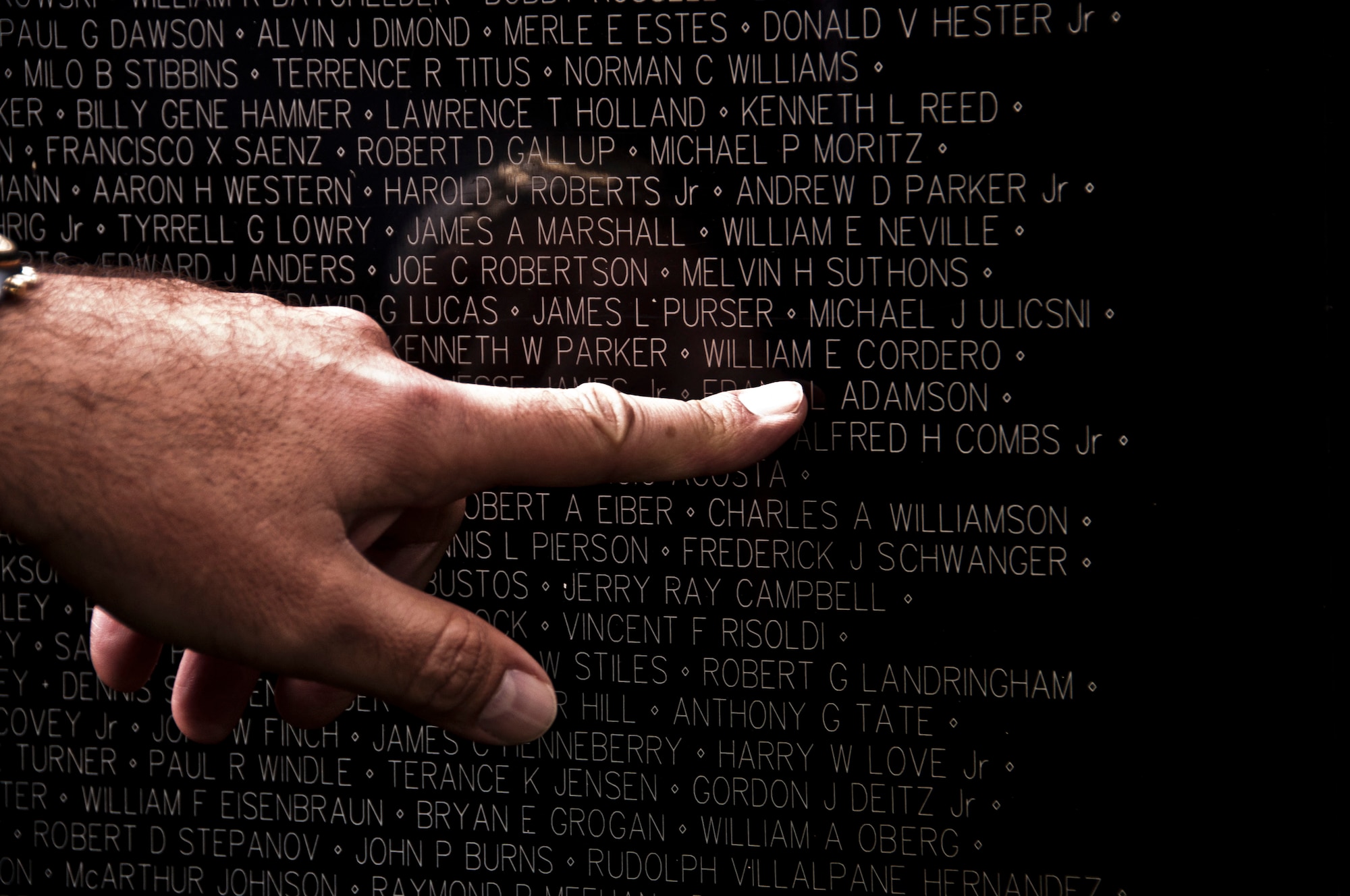 Tony Cordero points to his father's name, William Cordero, on Panel 2E, Row 15 of the Vietnam Memorial Wall replica after the opening ceremony Feb. 27 in Sacaramento Calif. William Cordero was a navigator in the Air Force and was killed in action during a bombing mission in a B-57. (U.S. Air Force photo/Senior Airman Madelyn Brown)