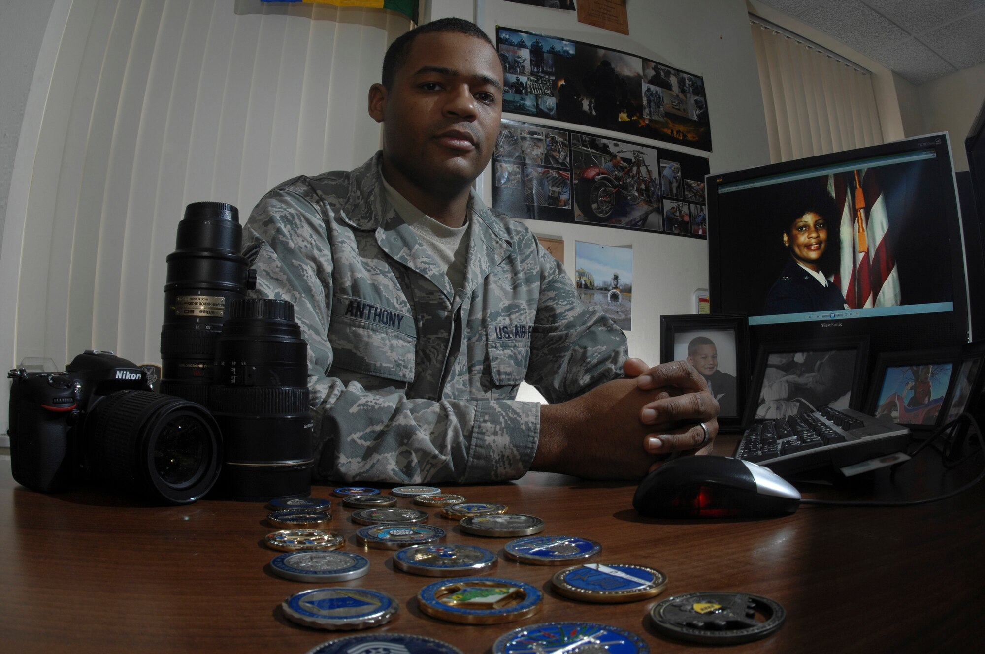 U.S. Air Force Senior Airman Micaiah Anthony, 100th Air Refueling Wing Public Affairs photojournalist, reflects on childhood memories March 6, 2014 at his desk on RAF Mildenhall, England. Anthony joined in May 2010 and attributes his service to his mother, retired United States Air Force Maj. Yoland Sue Anthony.  (U.S. Air Force photo by Senior Airman Micaiah Anthony/Released)
