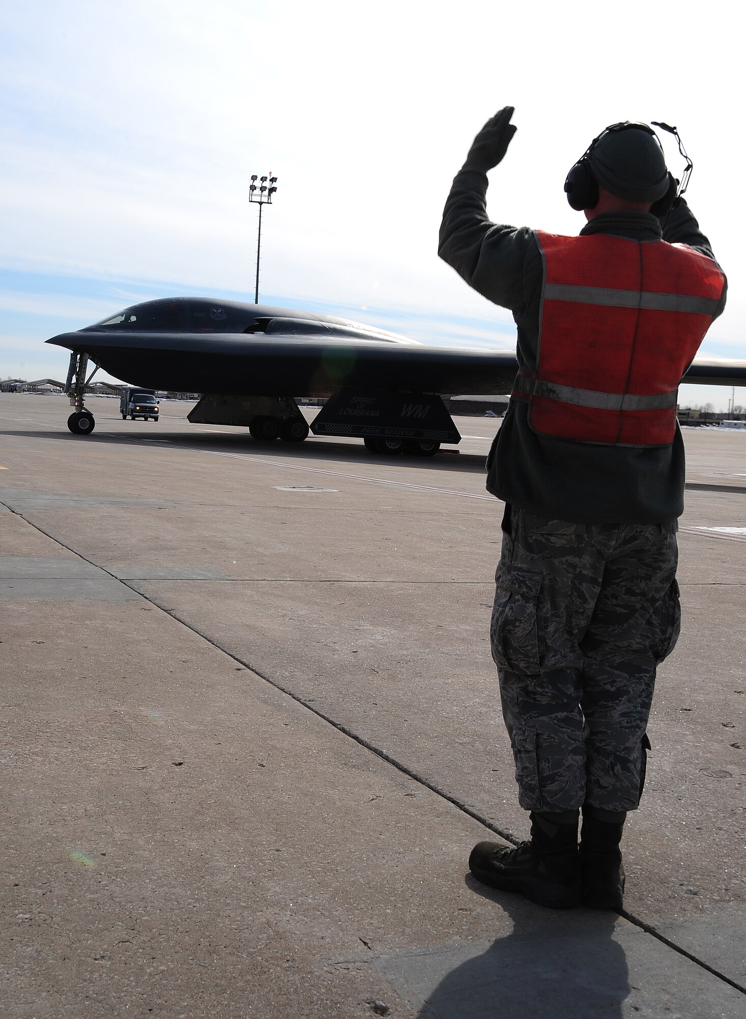 Senior Airman Joshua Thompson, 509th Aircraft Maintenance Squadron crew chief, marshals a B-2 Spirit after performing an engine-run and crew-change at Whiteman Air Force Base, Mo., Feb. 24, 2014. Pilots and crew chiefs conduct pre-flight inspections to ensure all components of the jet are mission-capable before flight. (U.S. Air Force photo by Staff Sgt. Nick Wilson/Released)