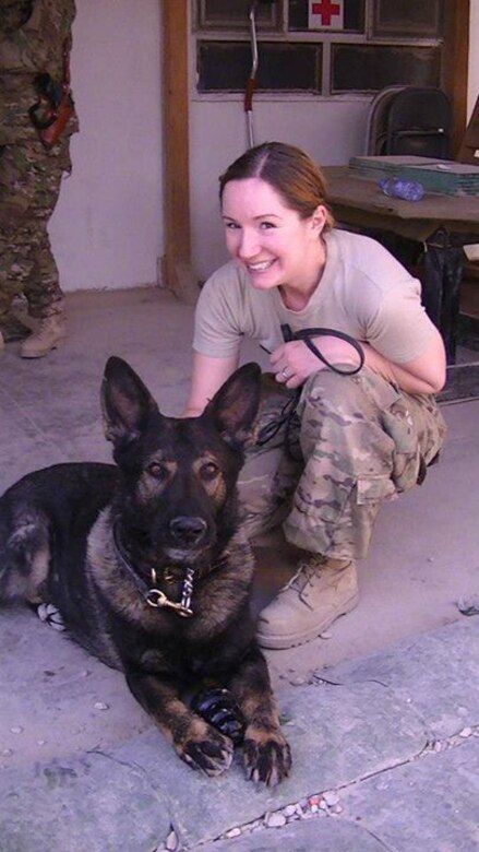 Nurse Capt. Allyson Dossman poses with Basco, a military working dog, at Forward Operating Base Lagman, Afghanistan, during her 2012-2013 deployment to the Miranda Trauma Center Forward Surgical Team. Now chief of the Yellow Ribbon Psychological Health Advocacy Program for Air Force Reserve Command, Dossman said research shows that petting a dog is linked to reduced blood pressure, lowered heart rate and an increased sense of well-being. (Courtesy photo)