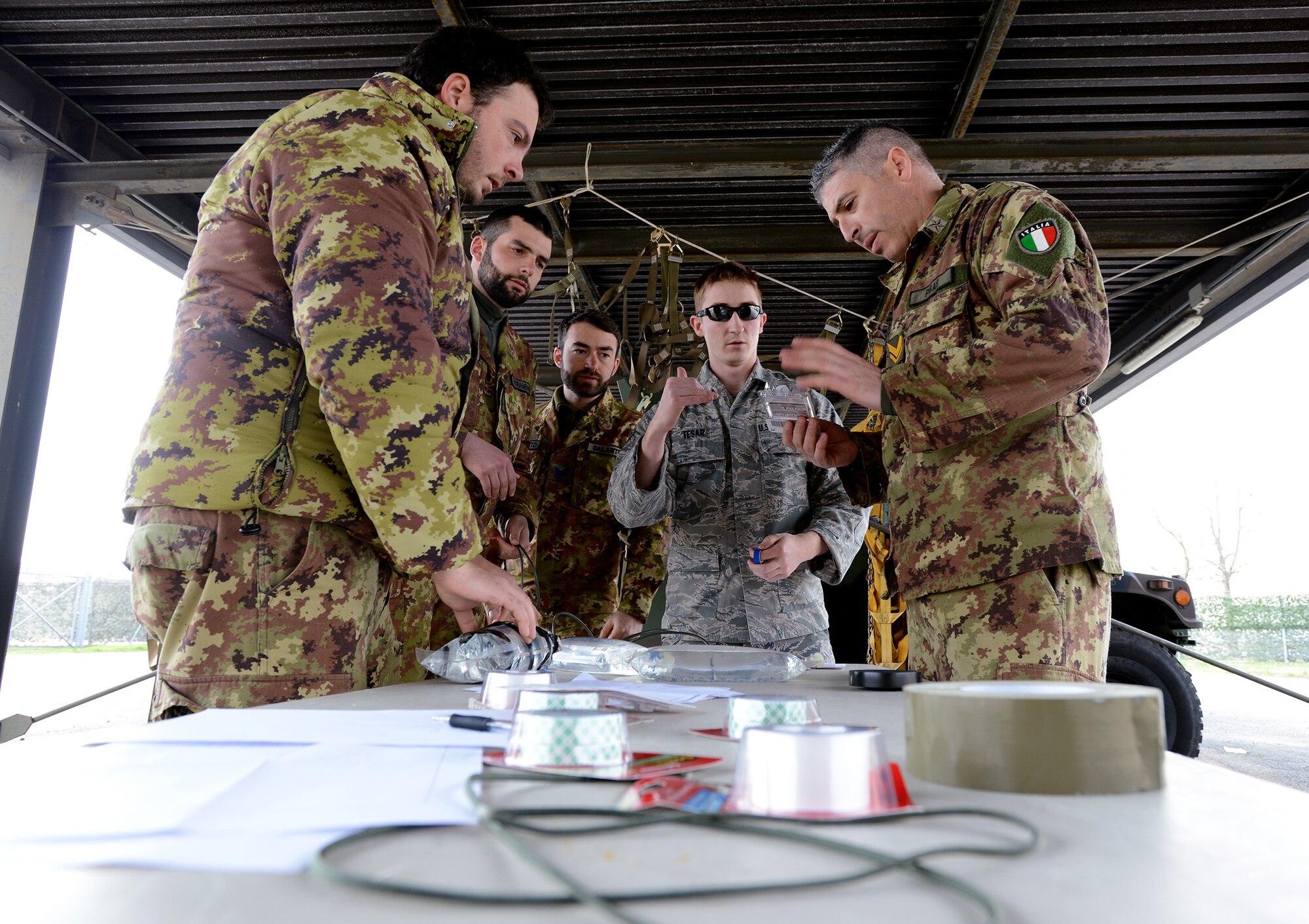 Senior Airman Drew Tesar , center, 31st Civil Engineer Squadron explosive ordnance disposal technician, discusses the explosive properties of improvised breaching charges Feb. 26, 2014, at Aviano Air Base, Italy. U.S. Air Force and Italian army EOD technicians teamed up Feb. 26-27, 2014, for dynamic entry training. (U.S. Air Force photo/Staff Sgt. R.J. Biermann)