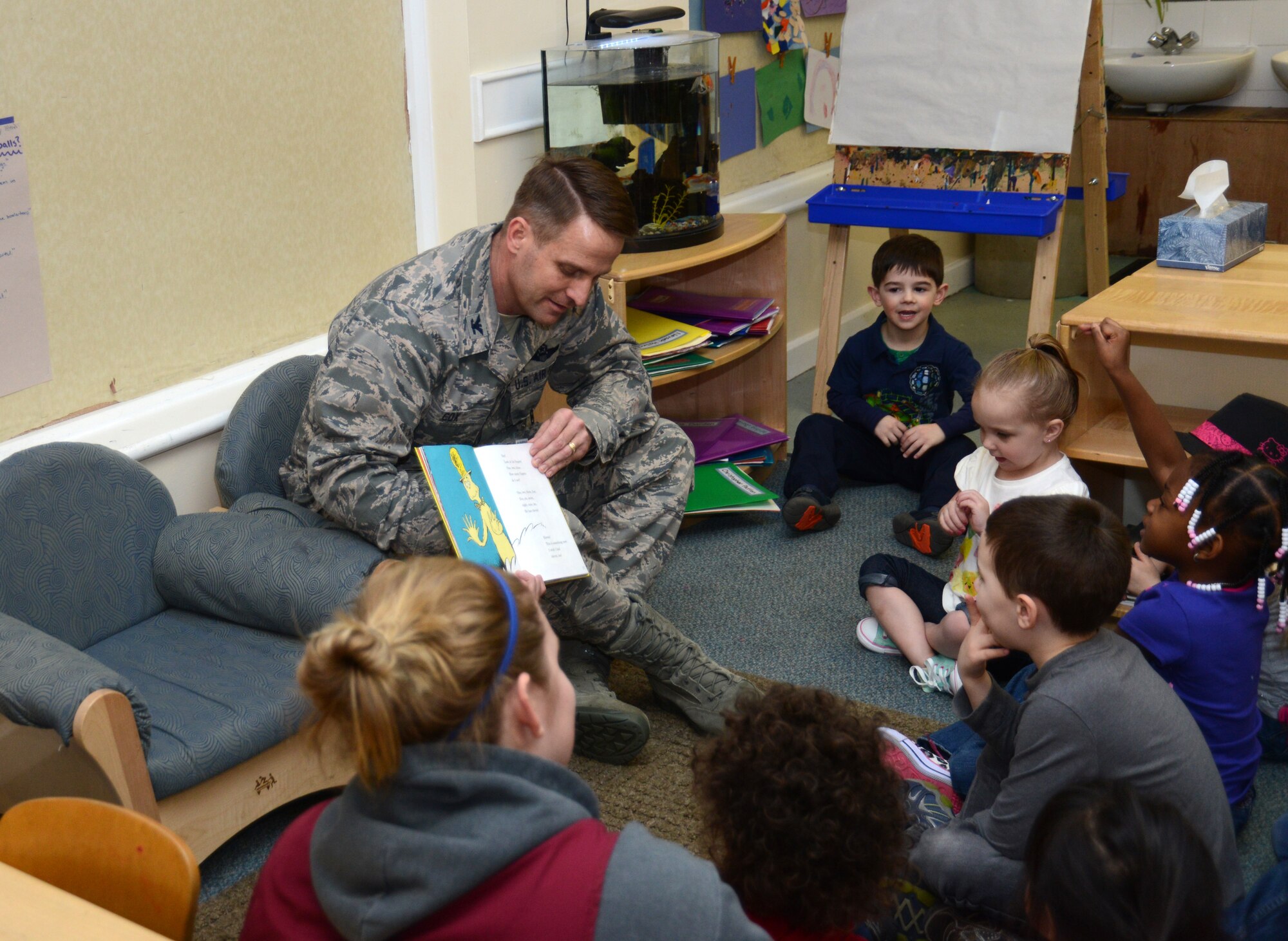 U.S. Air Force Col. David Cox, 100th Air Refueling Wing vice commander, reads “One Fish, Two Fish, Red Fish, Blue Fish” March 3, 2014, to children at the Child Development Center on RAF Mildenhall, England. Cox read to the children in celebration of National Read Across America Day. Other events included a breakfast of green eggs and ham and a door decorating contest. (U.S. Air Force photo by Airman 1st Class Kelsey Waters/Released)