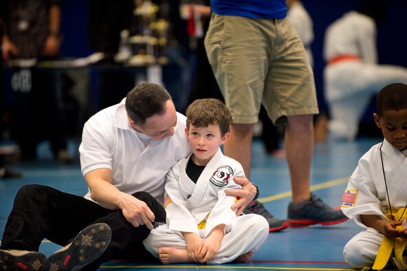 Anthony Bendele, son of Staff Sgt. Brandon Bendele, 435th Security Forces Squadron combat arms, is comforted by his coach after a difficult sparring match during the 2014 U.S. Air Forces in Europe and Air Forces Africa martial arts tournament March 1, 2014, Ramstein Air Base, Germany. The 2014 USAFE-AFFRICA martial arts tournament promotes good sportsmanship, healthy competition, and a way for children and teenagers to stay active. (U.S. Air Force photo/Airman 1st Class Jordan Castelan)