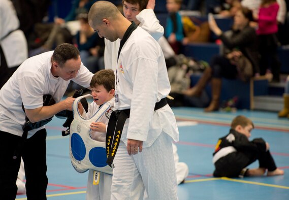 Anthony Bendele, son of Staff Sgt. Brandon Bendele, 435th Security Forces Squadron combat arms, is comforted by his coaches after a difficult sparring match during the 2014 U.S. Air Forces in Europe and Air Forces Africa martial arts tournament March 1, 2014, Ramstein Air Base, Germany. The 2014 USAFE-AFFRICA martial arts tournament promotes good sportsmanship, healthy competition, and a way for children and teenagers to stay active. (U.S. Air Force photo/Airman 1st Class Jordan Castelan)