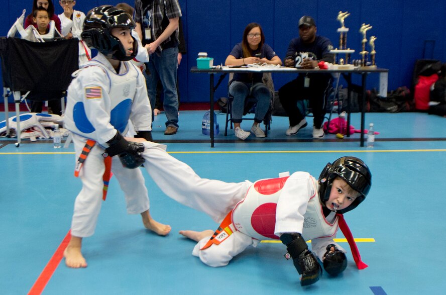 Hershel Theodore, blue sparing pads, son of Staff Sgt. Shermel Moven, Ramstein Contingency Aeromedical Staging Facility worker, catches a kick during a match during the 2014 U.S. Air Forces in Europe and Air Forces Africa martial arts tournament March 1, 2014, Ramstein Air Base, Germany. The 2014 USAFE-AFFRICA martial arts tournament promotes good sportsmanship, healthy competition, and a way for children and teenagers to stay active. (U.S. Air Force photo/Airman 1st Class Jordan Castelan)