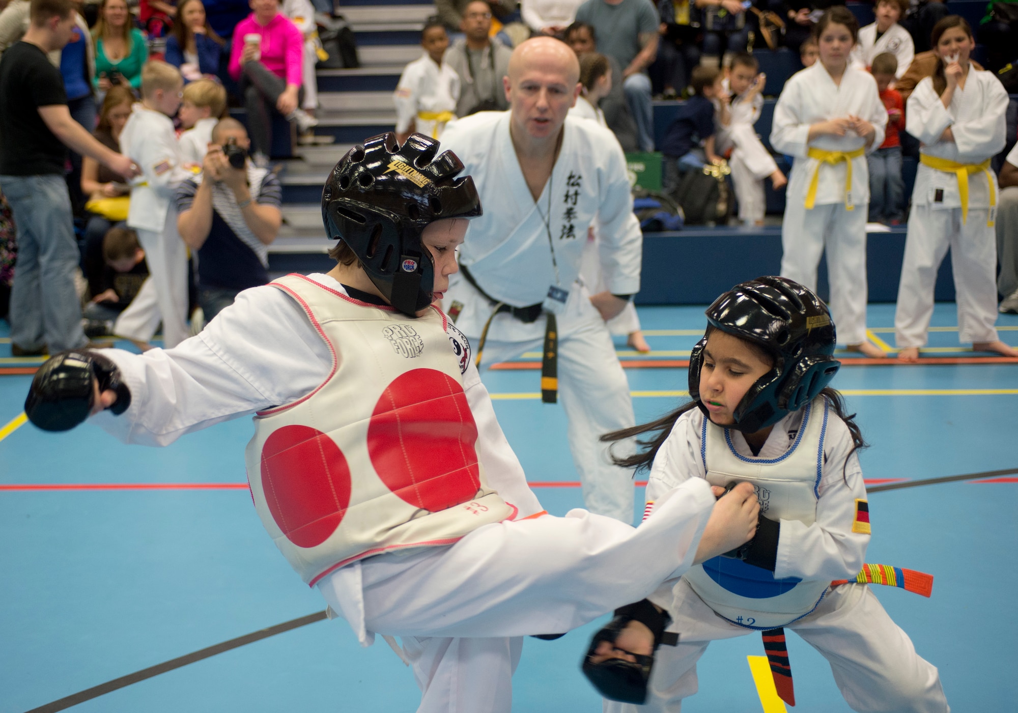 Jeysha Baez, blue sparring pads, blocks a kick during the 2014 U.S. Air Forces in Europe and Air Forces Africa martial arts tournament March 1, 2014, Ramstein Air Base, Germany. The 2014 USAFE-AFFRICA martial arts tournament promotes good sportsmanship, healthy competition, and a way for children and teenagers to stay active. (U.S. Air Force photo/Airman 1st Class Jordan Castelan)