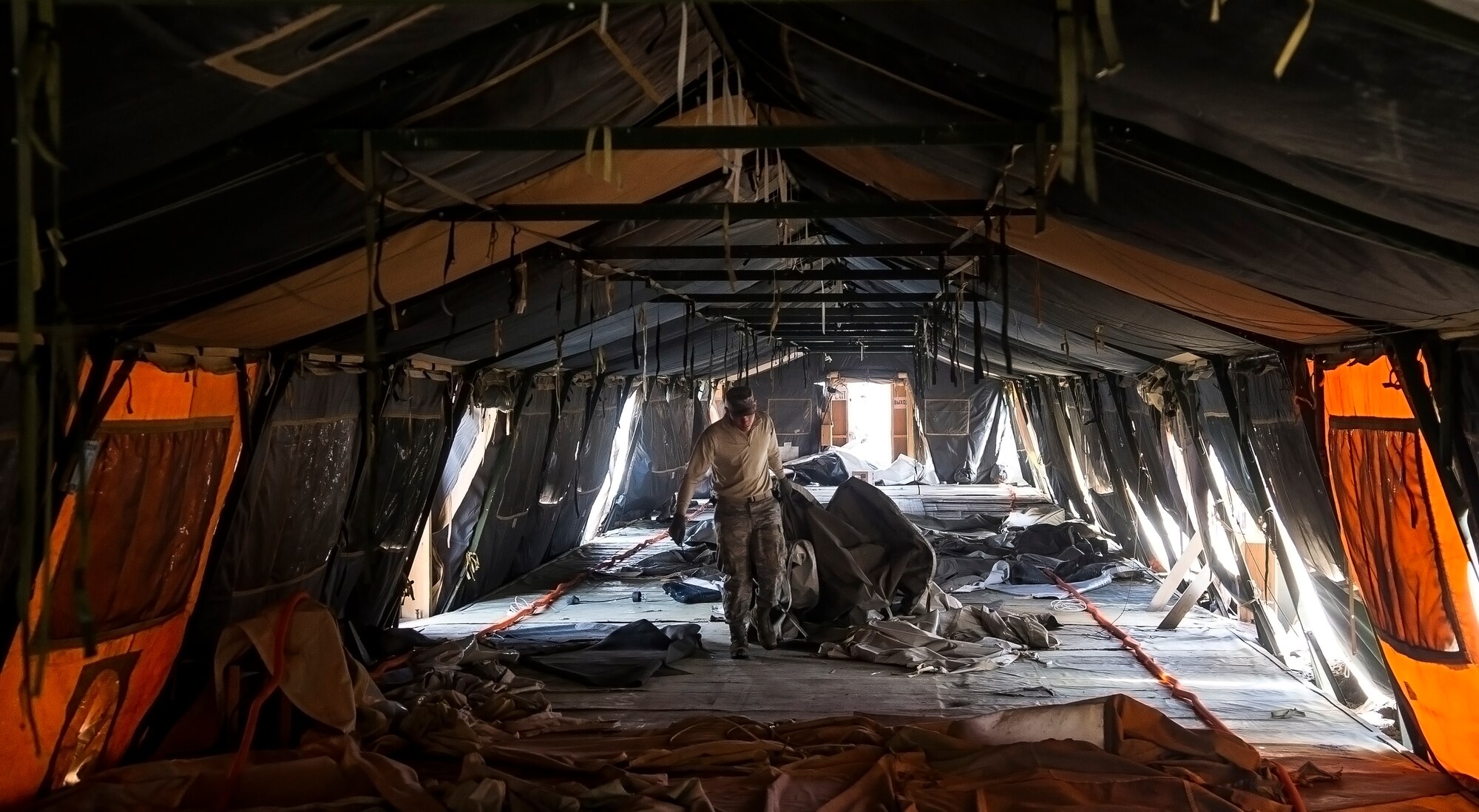 A member of the 376th Air Expeditionary Wing drags material through a tent at Transit Center at Manas, Kyrgyzstan, March 6, 2014. Personnel from various units volunteered to assist in the reduction efforts. (U.S. Air Force photo/Senior Airman George Goslin)


