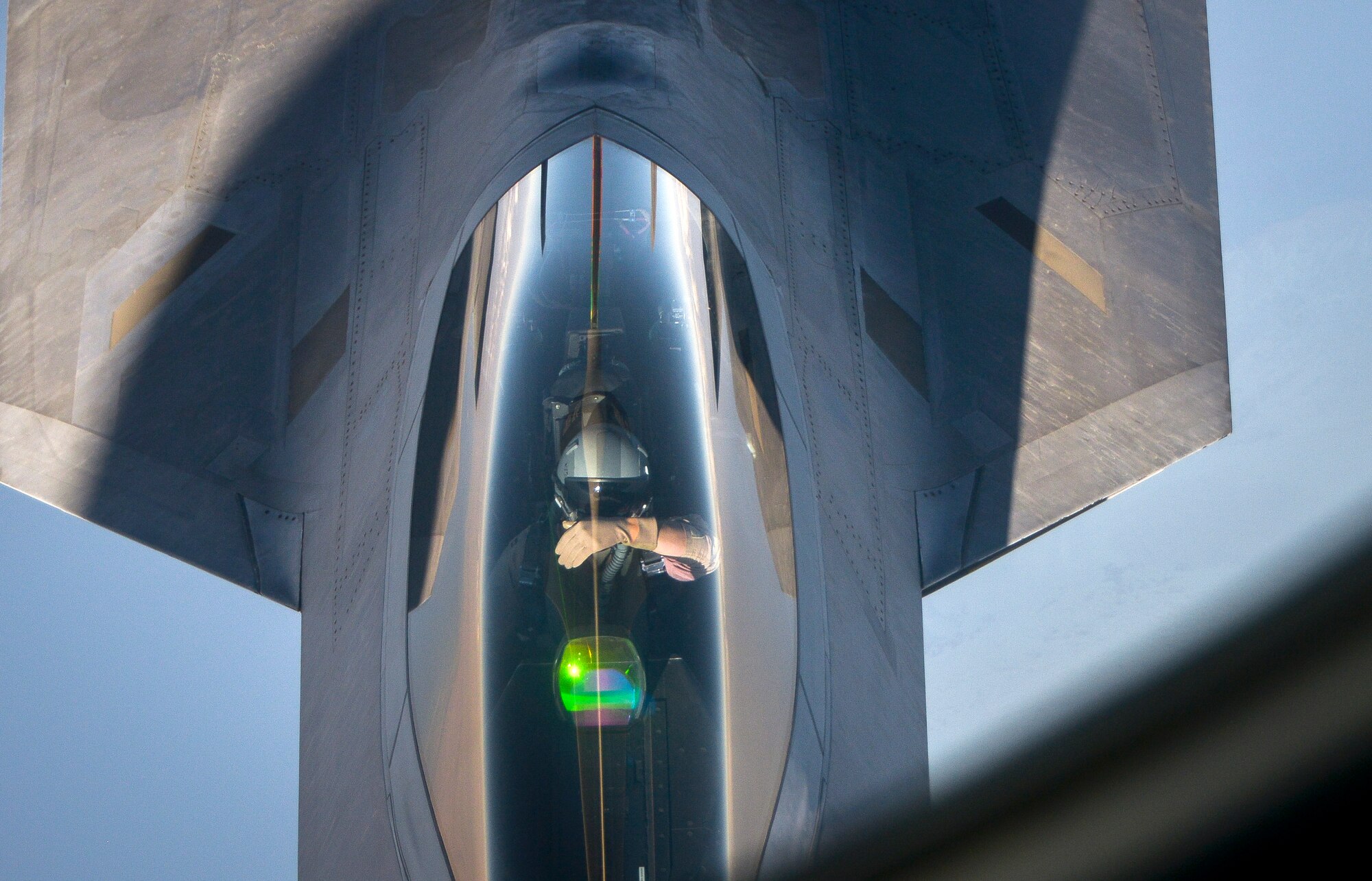 An F-22 Raptor pilot blocks out the sun to line up with the refueling boom of a KC-135 Stratotanker from the 340th Expeditionary Air Refueling Squadron at an undisclosed location in Southwest Asia, Feb. 26, 2014. Airmen from the 340th EARS at Al Udeid Air Base, Qatar, make up the U.S. Air Forces Central Command’s area of responsibility main refueling squadron which supports the aircraft of Operation Enduring Freedom. Aerial refueling extends the capabilities of any aircraft by expanding the range, limited only by crew fatigue and fuel consumption of the aircraft. (U.S. Air Force photo/Senior Airman Jared Trimarchi) 