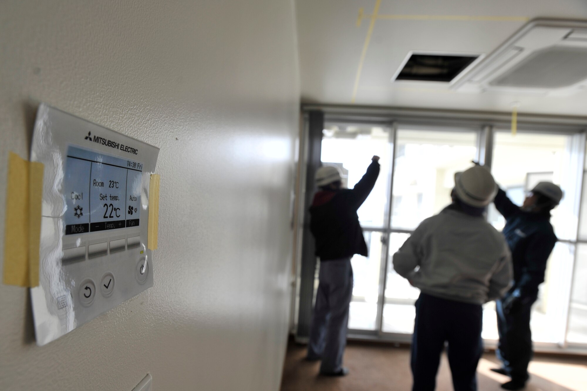 MISAWA AIR BASE, Japan – Japanese contractors from Ni Shi Matsu Construction Co., inspect the efficiency of the air conditioning units being installed inside a mock unit of building 1939, March 7, 2014. The 35th Civil Engineering Squadron recently awarded a $14 million project to install air conditioning into military housing units for 416 families on North Base. (U.S. Air Force photo/ Staff Sgt. Tong Duong)
