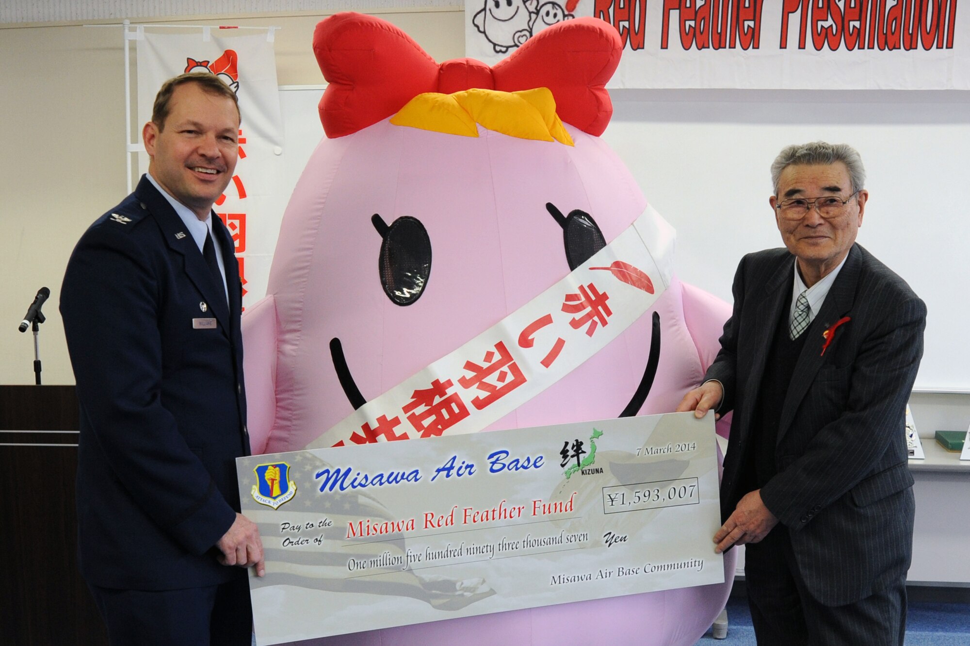 U.S. Air Force Col. Stephen Williams, 35th Fighter Wing commander, presents a check to Ishi Numata, Red Feather Fund president, at the Misawa International Center in Misawa City, Japan, March 7, 2014. Various organizations from Misawa Air Base collected and donated more than $1,500 toward the Red Feather Fund in 2013, which provides money for disaster relief, welfare facilities, handicapped citizens, and Misawa citizens in need. Since its inception in 1960, Misawa Air Base has donated more than $85,000 to the Red Feather Fund. (U.S. Air Force photo/Senior Airman Derek VanHorn)