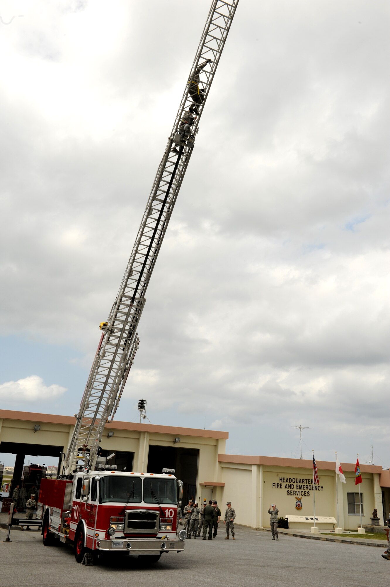Company grade officers of the Model Program climb the ladder of a fire truck during training on Kadena Air Base, Japan, March 6, 2014. The members visited the 18th Civil Engineer Squadron firefighters Kadena fire station as part of their tour of multiple units across the installation. Experiencing the career fields and learning about the various units on Kadena, the Model Program allows CGO?s to interact and train with members of the units. (U.S. Air Force photo by Airman 1st Class Keith James)