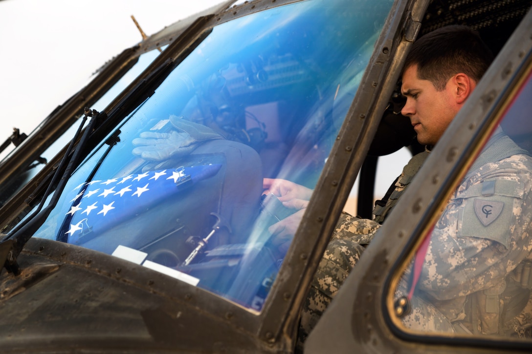 U.S. Army Cpt. James Caniff logs flight info after landing his UH-60 ...