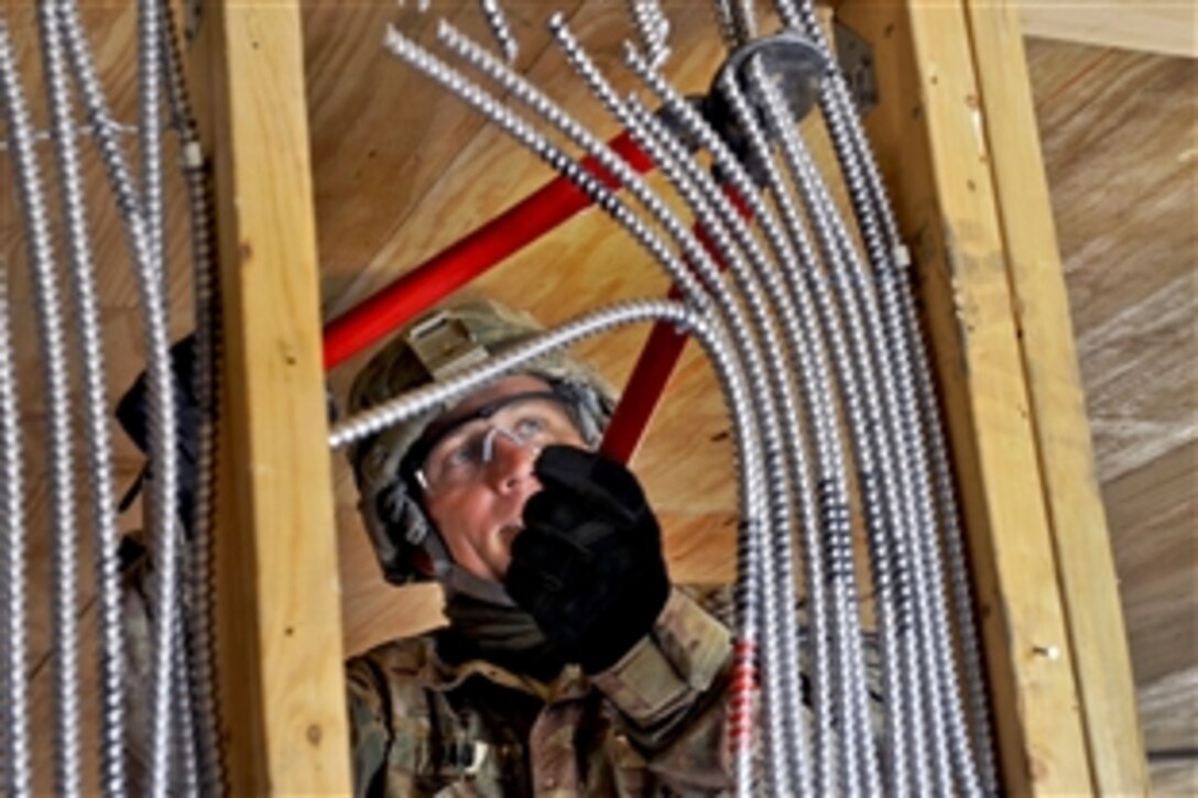 A U.S. soldier uses bolt cutters to sever electrical tubing inside a building on Kandahar Airfield, Afghanistan, Feb. 26, 2014. The soldier is a combat engineer assigned to the 1223rd and 955th Engineer companies. The units have deconstructed more than 1,000 structures during their deployment and have been vital in aiding with the closure of numerous bases.