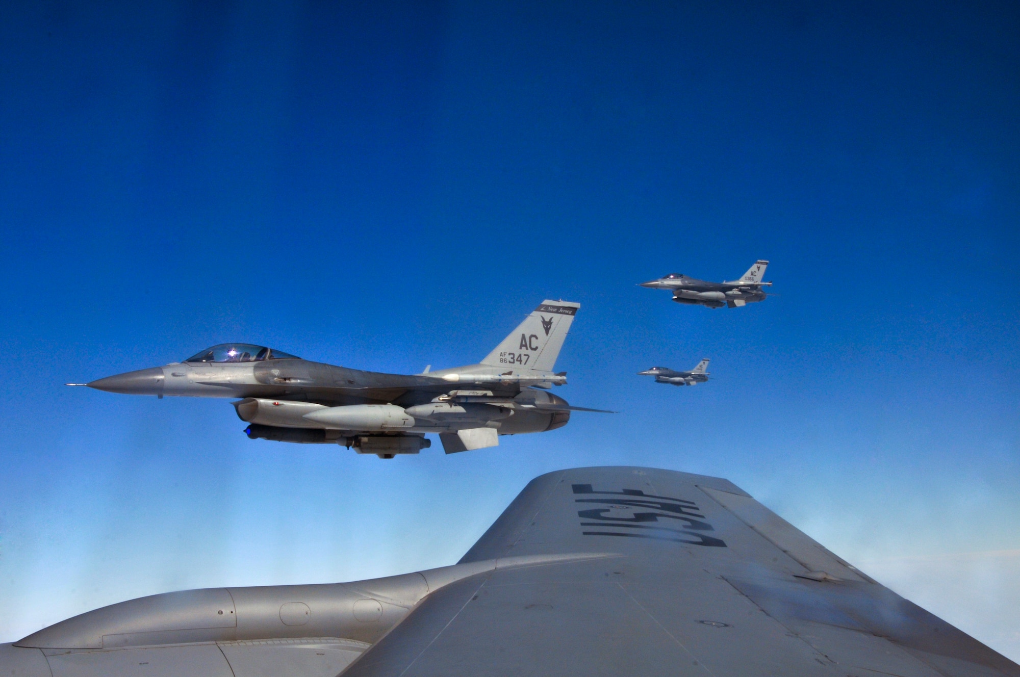 A picture of three U.S Air Force F-16 Fighting Falcons flying near a 191st Air Refueling Squadron KC-135 Stratotanker.