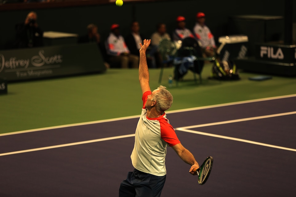 John McEnroe tosses up a tennis ball to serve during the John McEnroe Challenge for Charity at the Indian Wells Tennis courts March 1, 2014. The day of he event was also the grand opening of Stadium 2, a new tennis court in the facility.