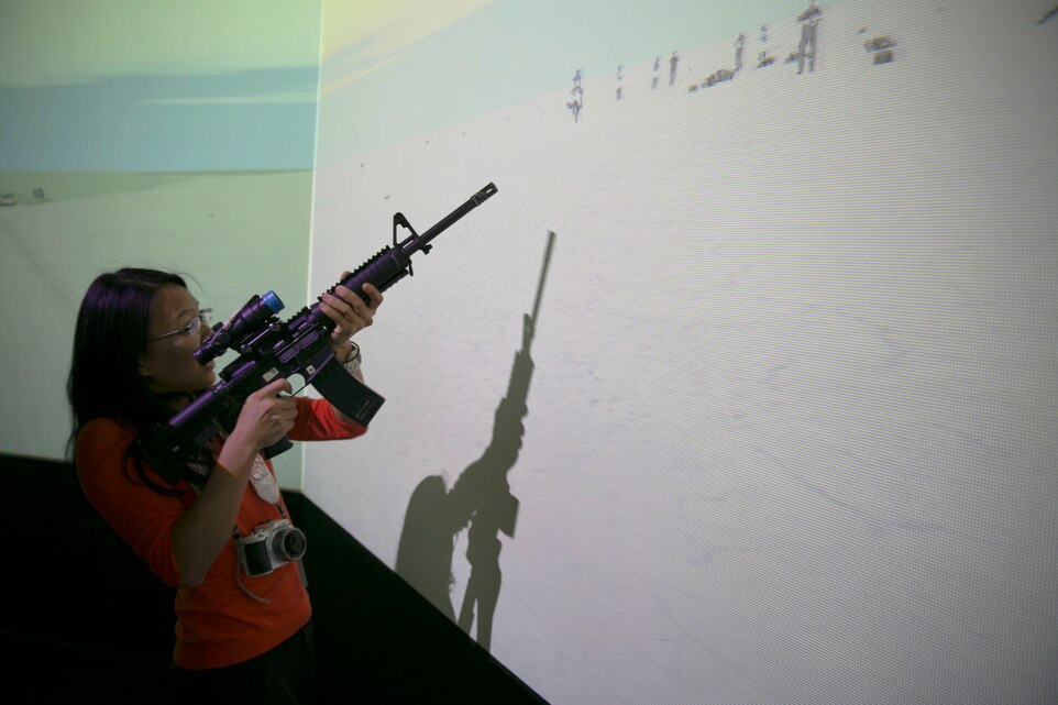 Tracy Yu, student, University of Southern California, fires at simulated enemies at the Battle Simulation Center during a tour of the Combat Center, March 4, 2014. The majority of the tour participants expressed an interest in working with military families upon completion of their schooling. (Official Marine Corps Photo By Lance Cpl. Kasey Peacock/Released)