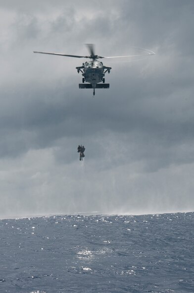 An MH-60s Seahawk helicopter assigned to Helicopter Sea Combat Squadron 25 lifts a simulated downed aircrew member and a rescue swimmer out of the water during an Exercise Cope North 2014 search and rescue scenario Feb. 19. Cope North is a multilateral field training exercise that brings together the U.S. Air Force, Japan Air Self-Defense Force, Royal Australian Air Force and the Republic of Korea Air Force in order to strengthen regional partner warfighter integration, humanitarian assistance and disaster relief interoperability training. (U.S. Air Force photo by Senior Airman Katrina M. Brisbin/Released)