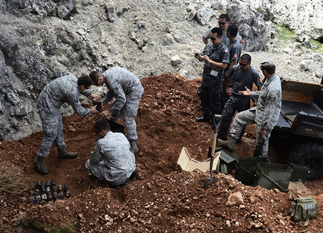 Members of the Japan Air Self-Defense Force’s 83rd Air Wing observe 36th Civil Engineer Squadron Explosive Ordnance Disposal Flight Airmen arranging unexploded ordnances before a demolition demonstration Feb. 21, 2014, on Andersen Air Force Base, Guam. The JASDF Airmen were here as part of Exercise Cope North 2014, a multilateral training event designed to improve the mission readiness and combined interoperability of the U.S. Air Force, JASDF, and the Royal Australian Air Force. (U.S. Air Force photo by Airman 1st Class Amanda Morris/Released)